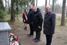 trzech mężczyzn stoi przed pomnikiem