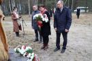dwóch mężczyzn i kobieta stoją przed pomnikiem