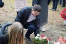 młody chłopiec kładzie kwiaty