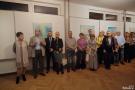 zgromadzone osoby stojące przy obrazach