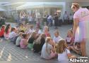 dzieci siedzą na kostce brukowej