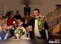 mężczyzna podczas występu rozdaje kwiaty