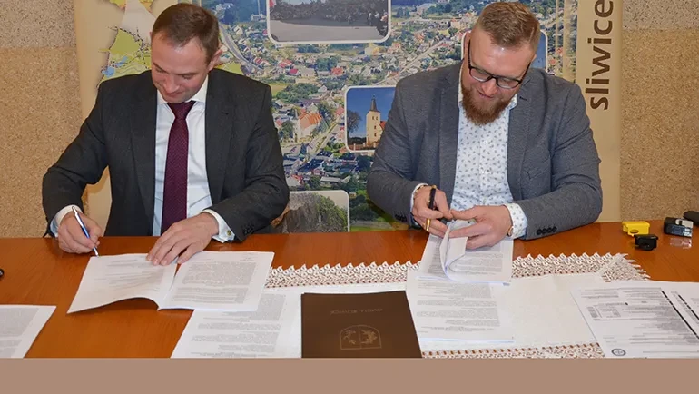 Dwóch mężczyzn podpisujący umowy