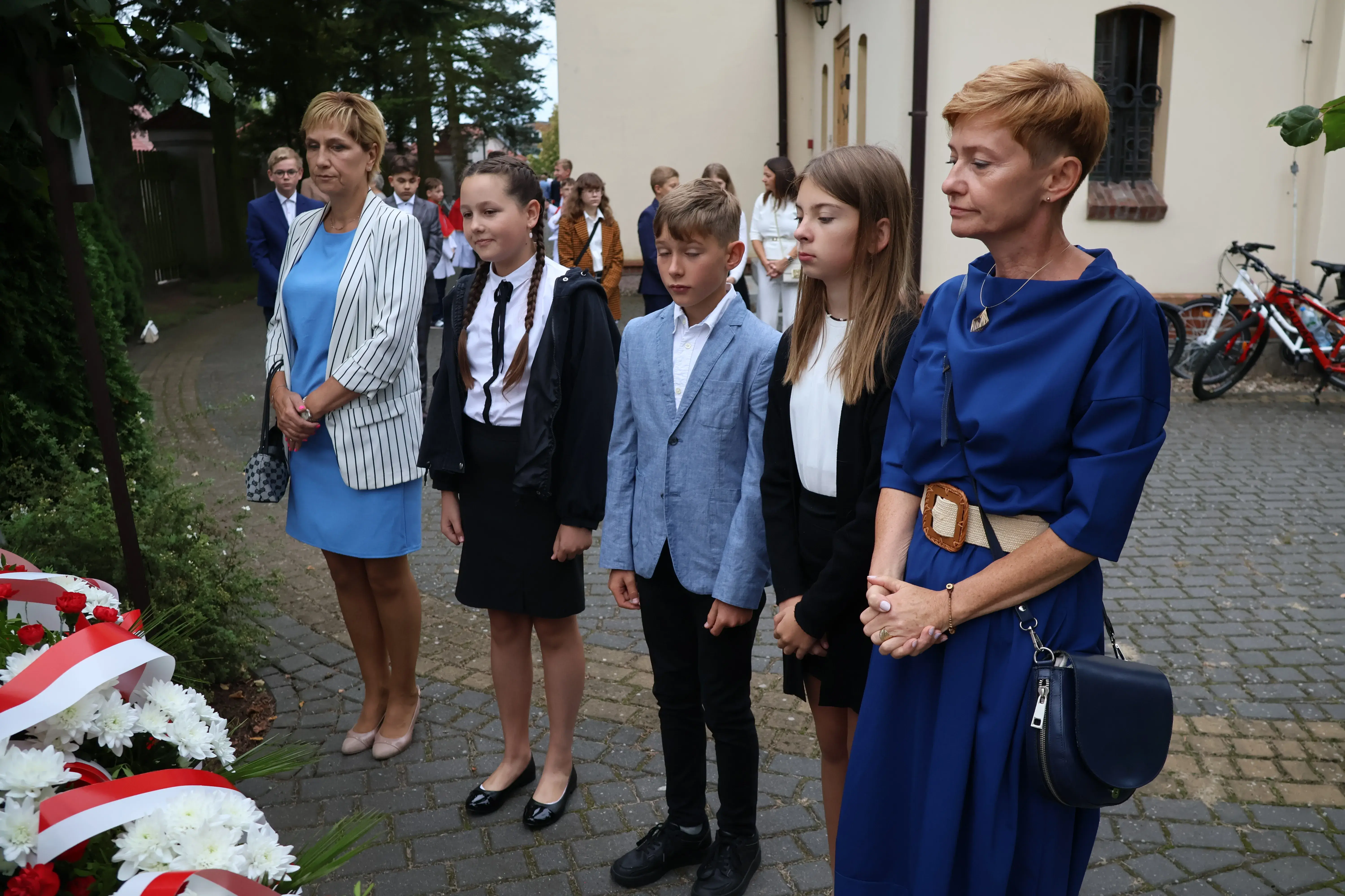 Przedstawiciele stoją przed pomnikiem