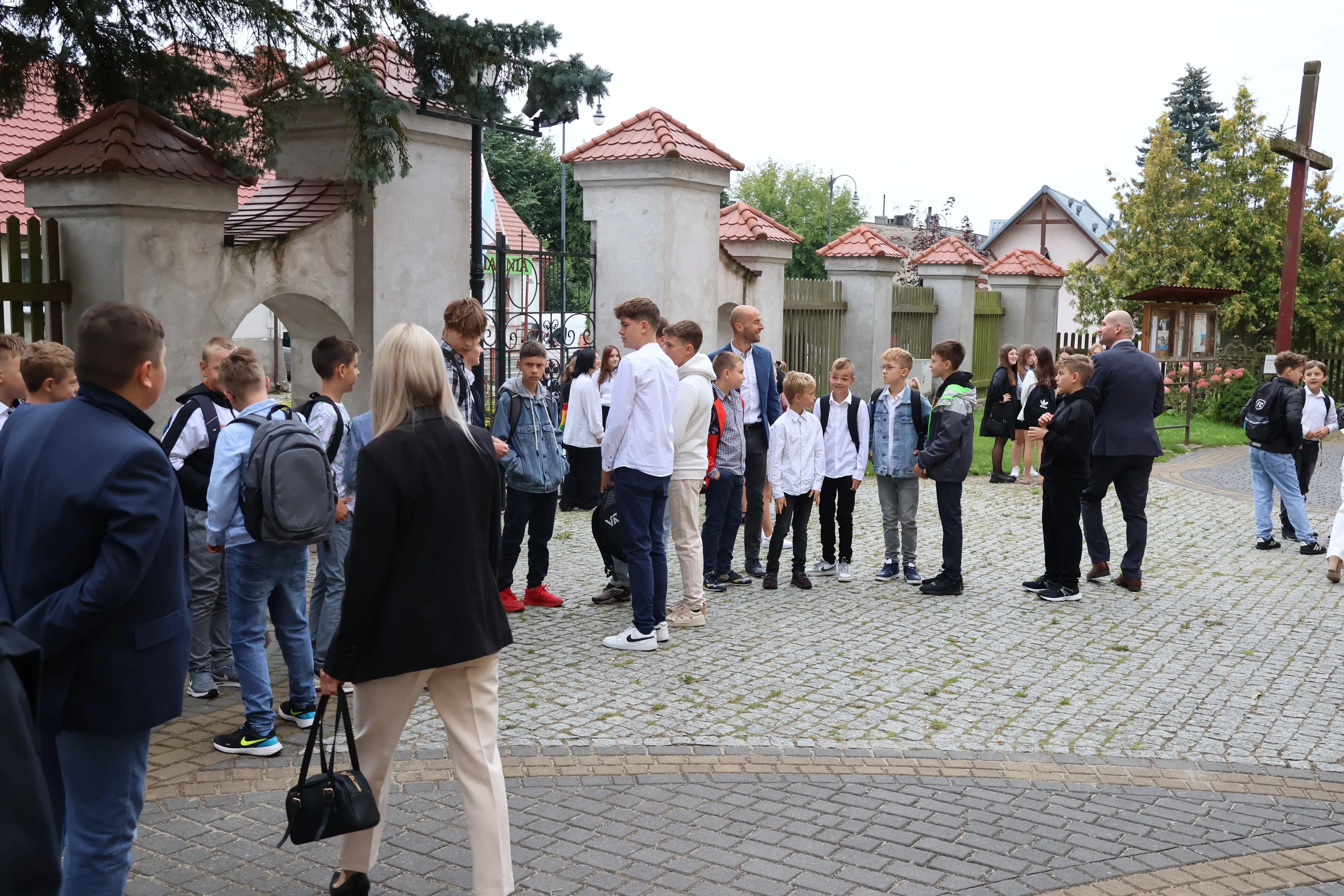 Uczniowie stoją przed kościołem
