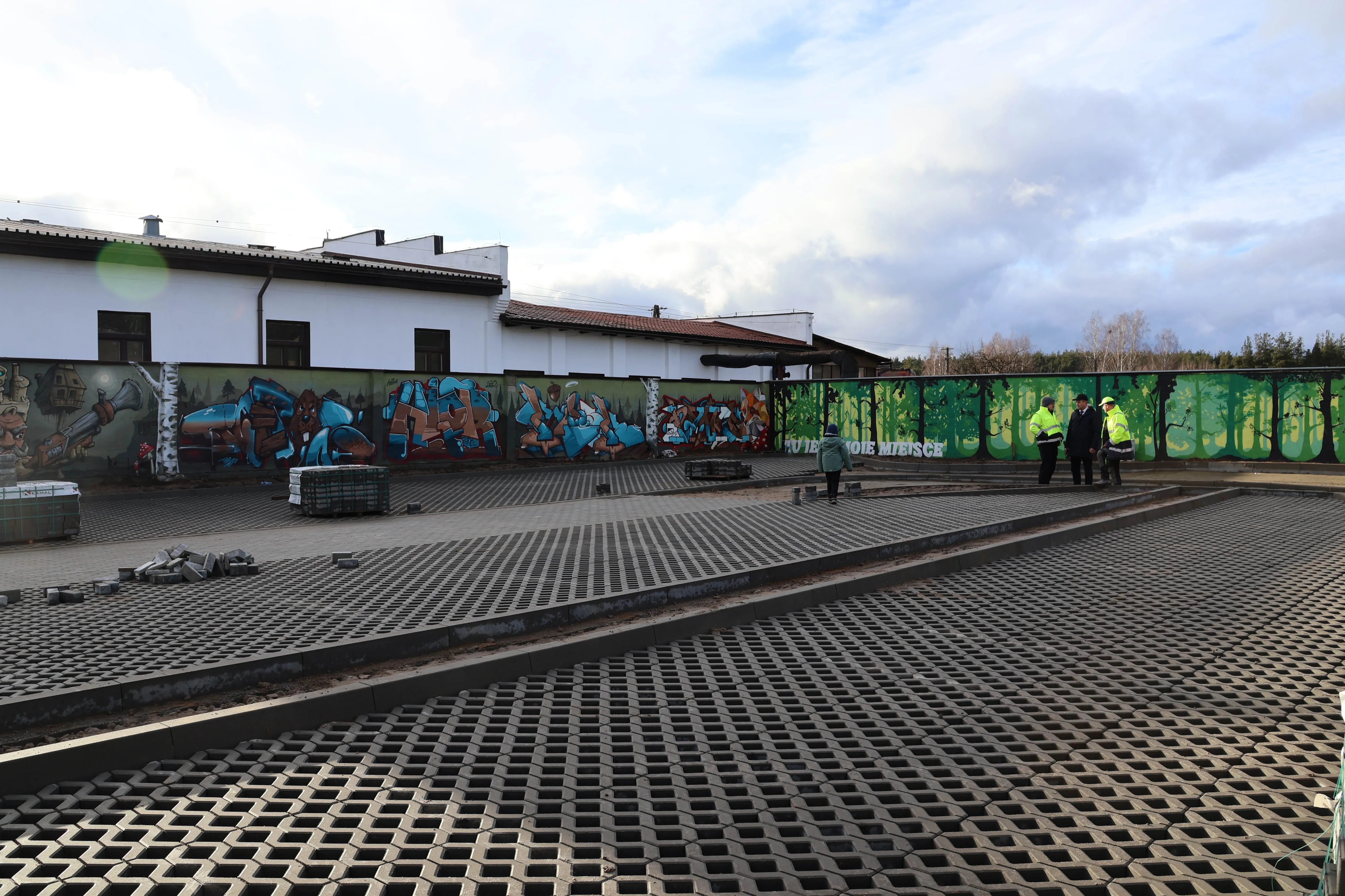 nowy parking, wyłożony kostką, w tle śliwickie murale