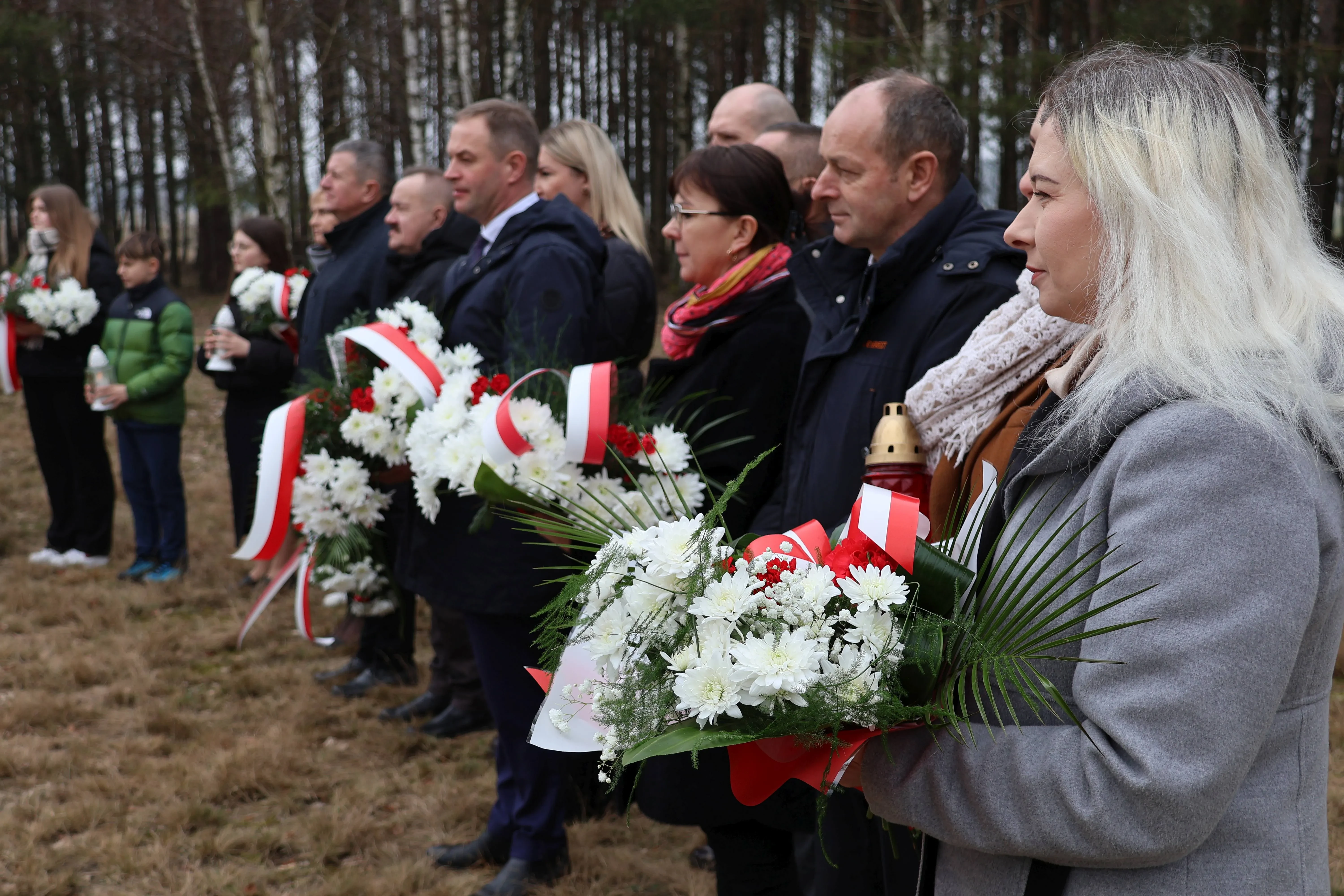 ludzie trzymający bukiety kwiatów