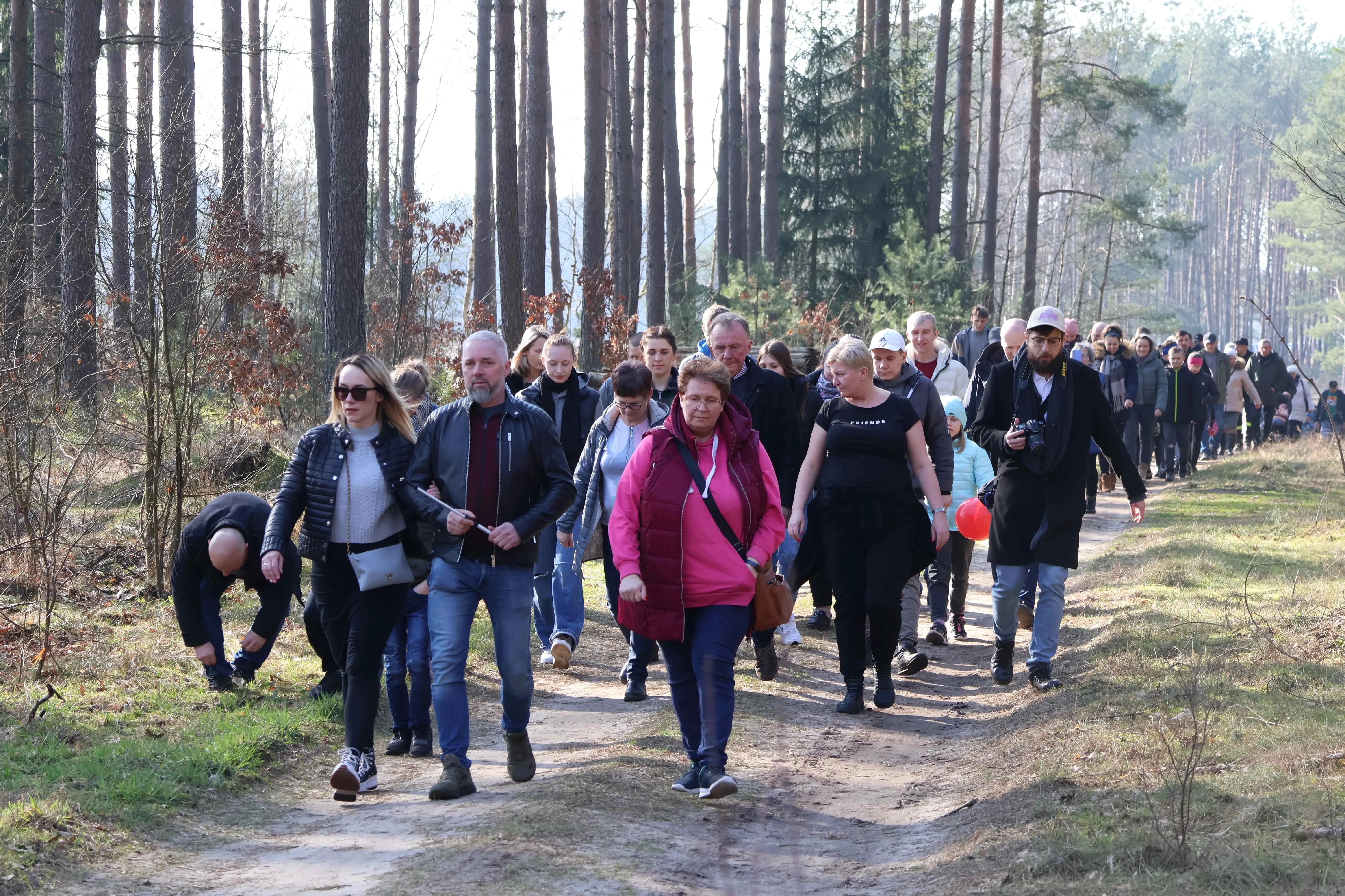 grupa ludzi idzie przez las