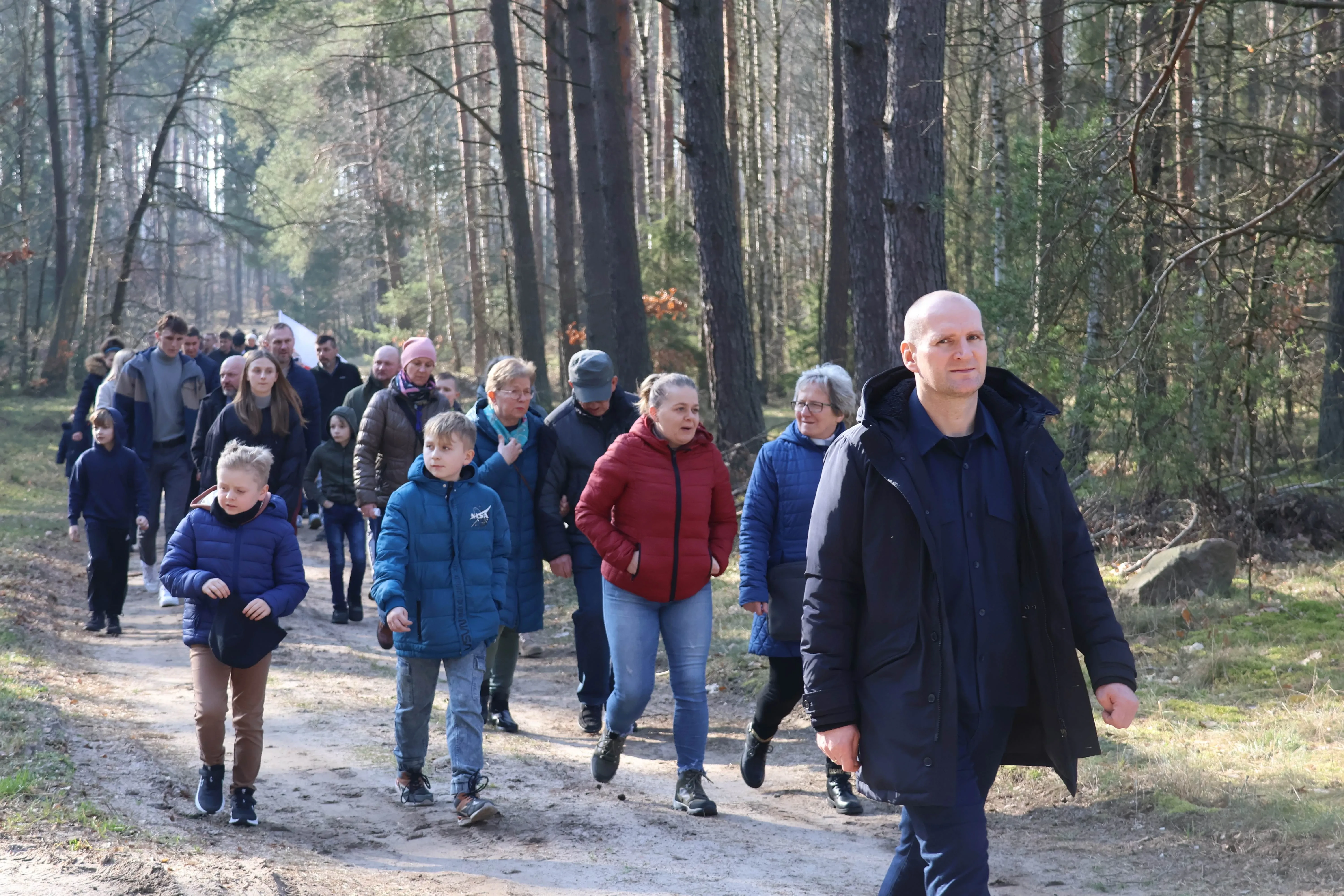 ludzie idą przez las