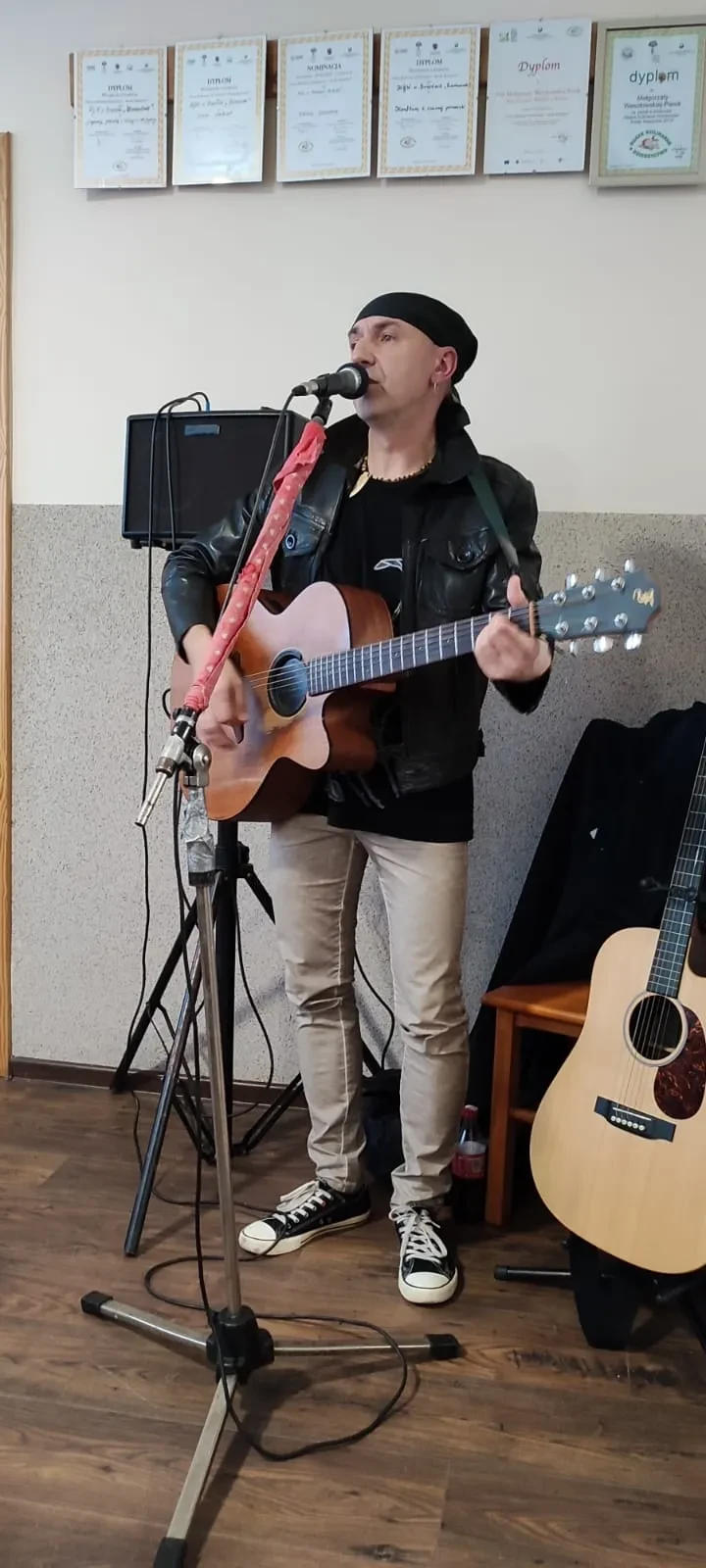 człowiek gra na gitarze i śpiewa