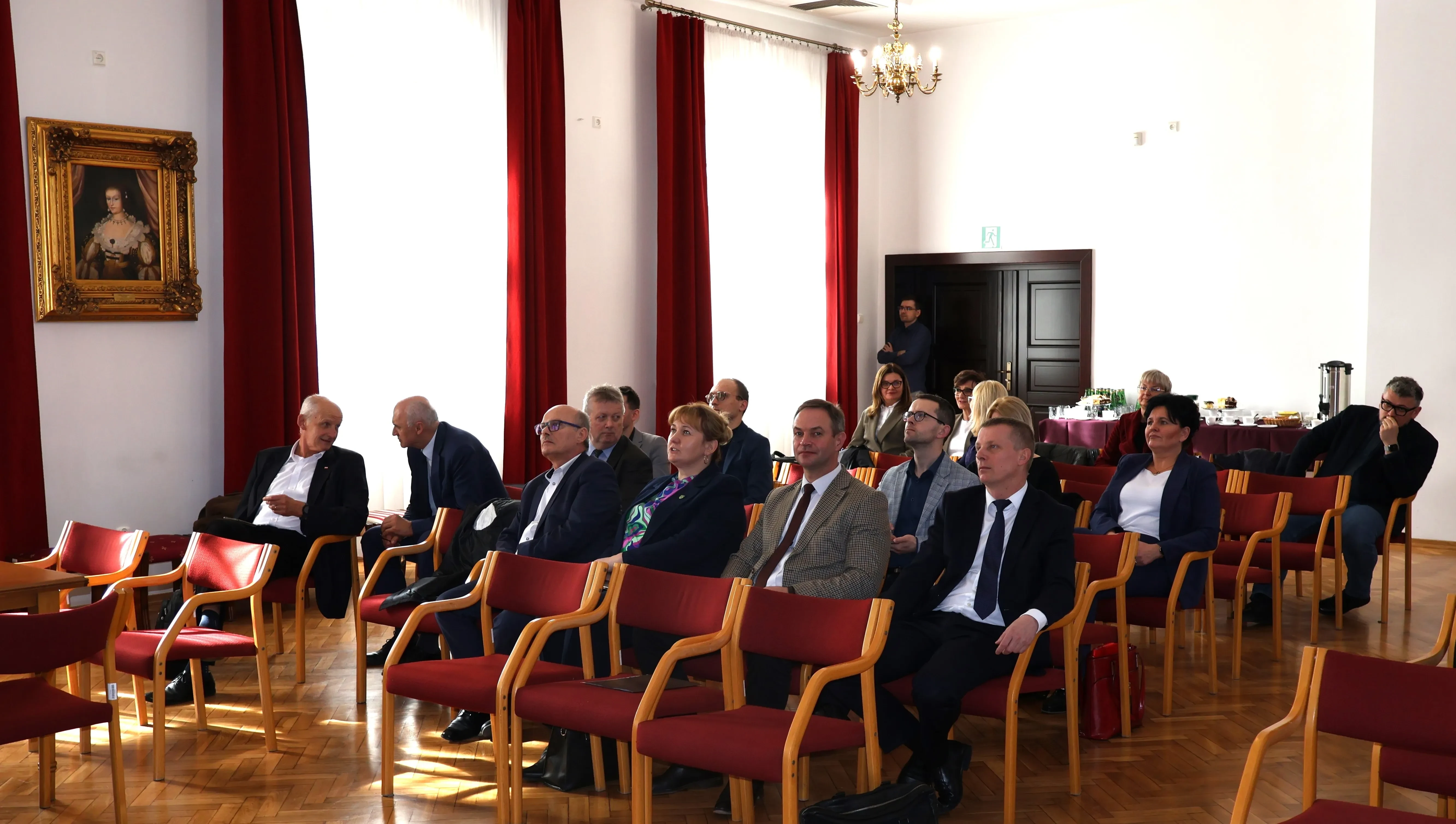 grupa ludzi siedzi w sali