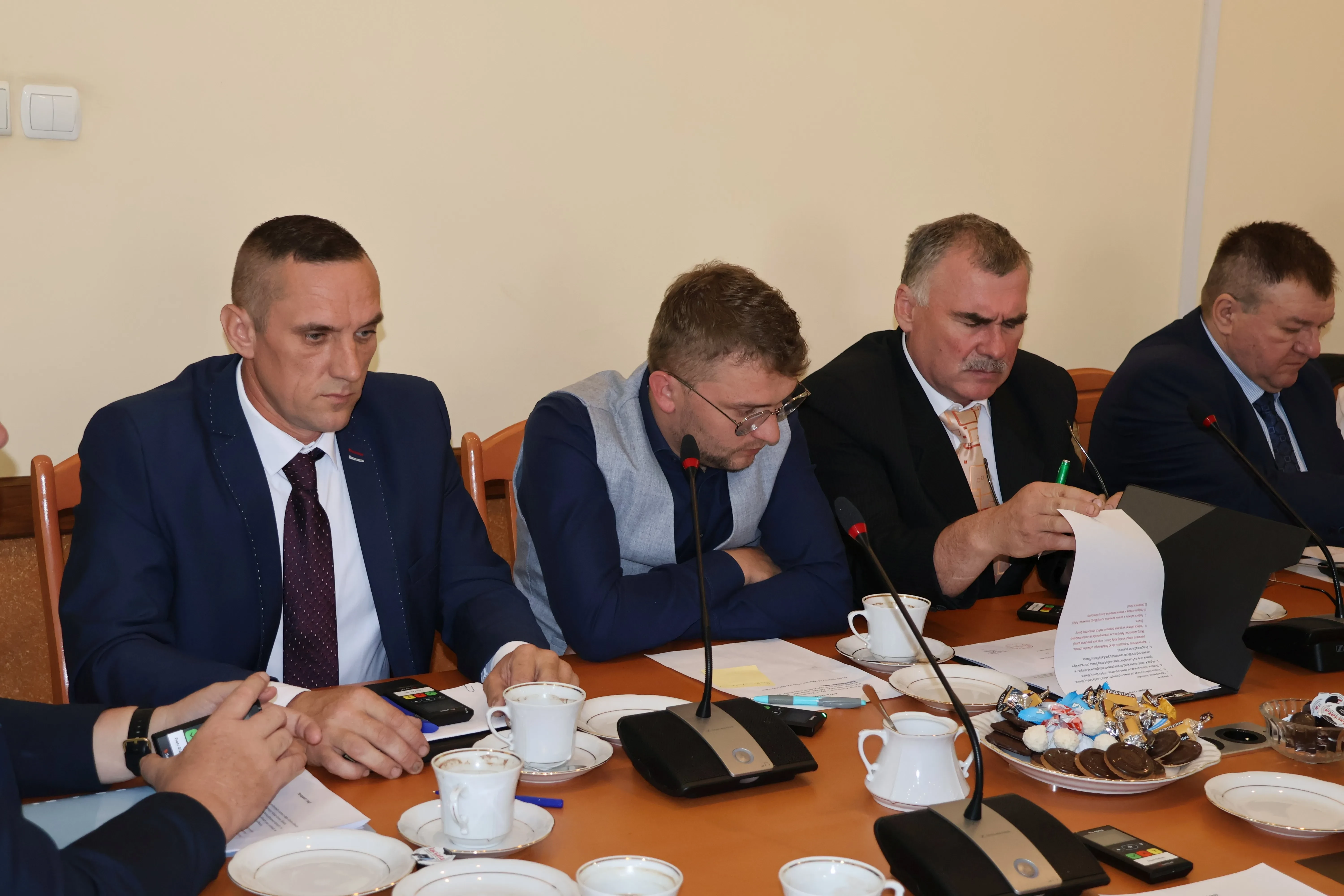 trzech mężczyzn siedzi przy stole