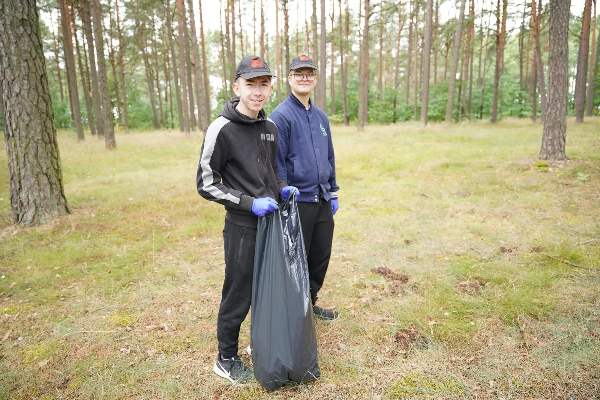 chłopacy zbierają śmieci
