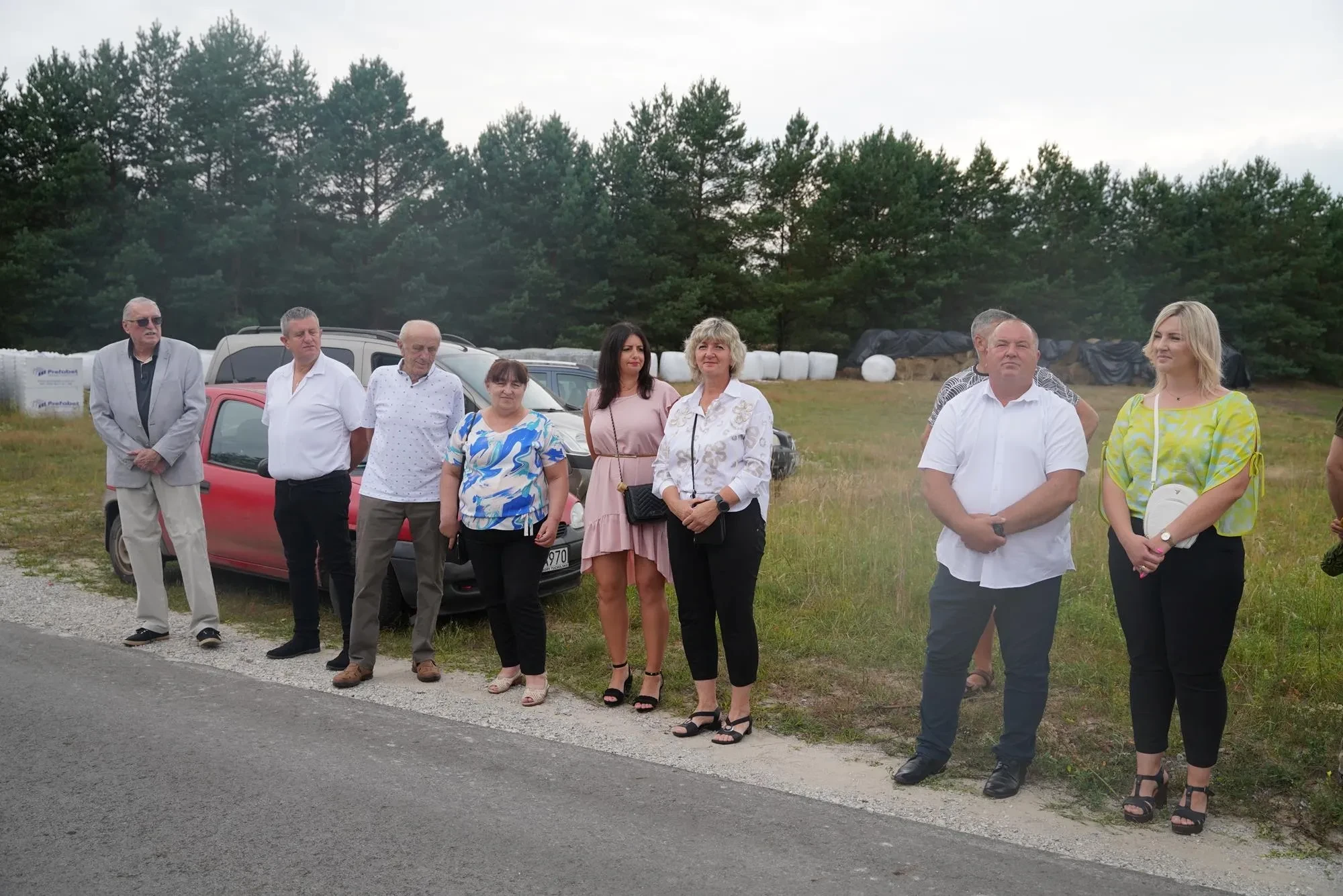 zebrani stoją przy drodze