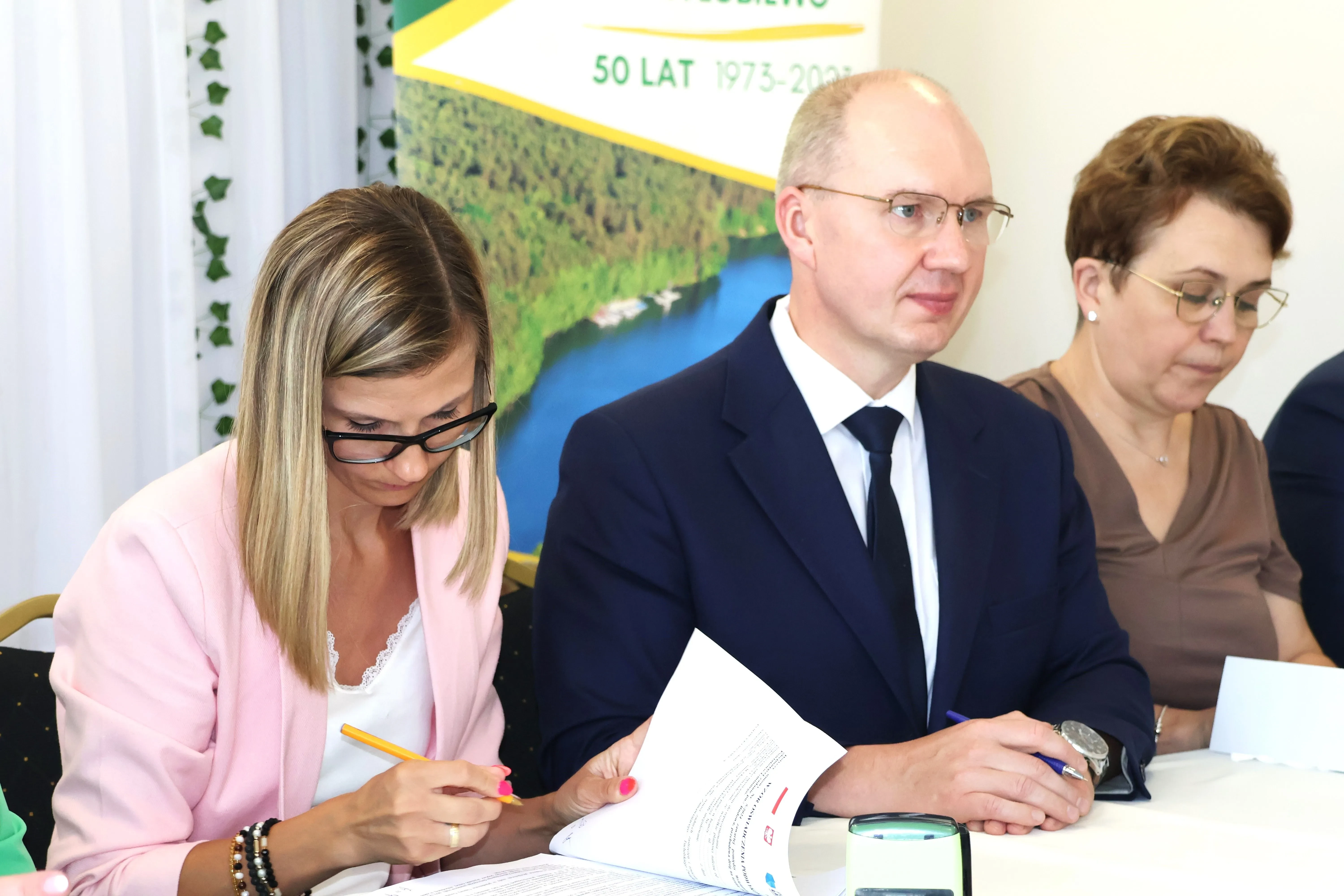 3 osoby przy podpisywaniu umów