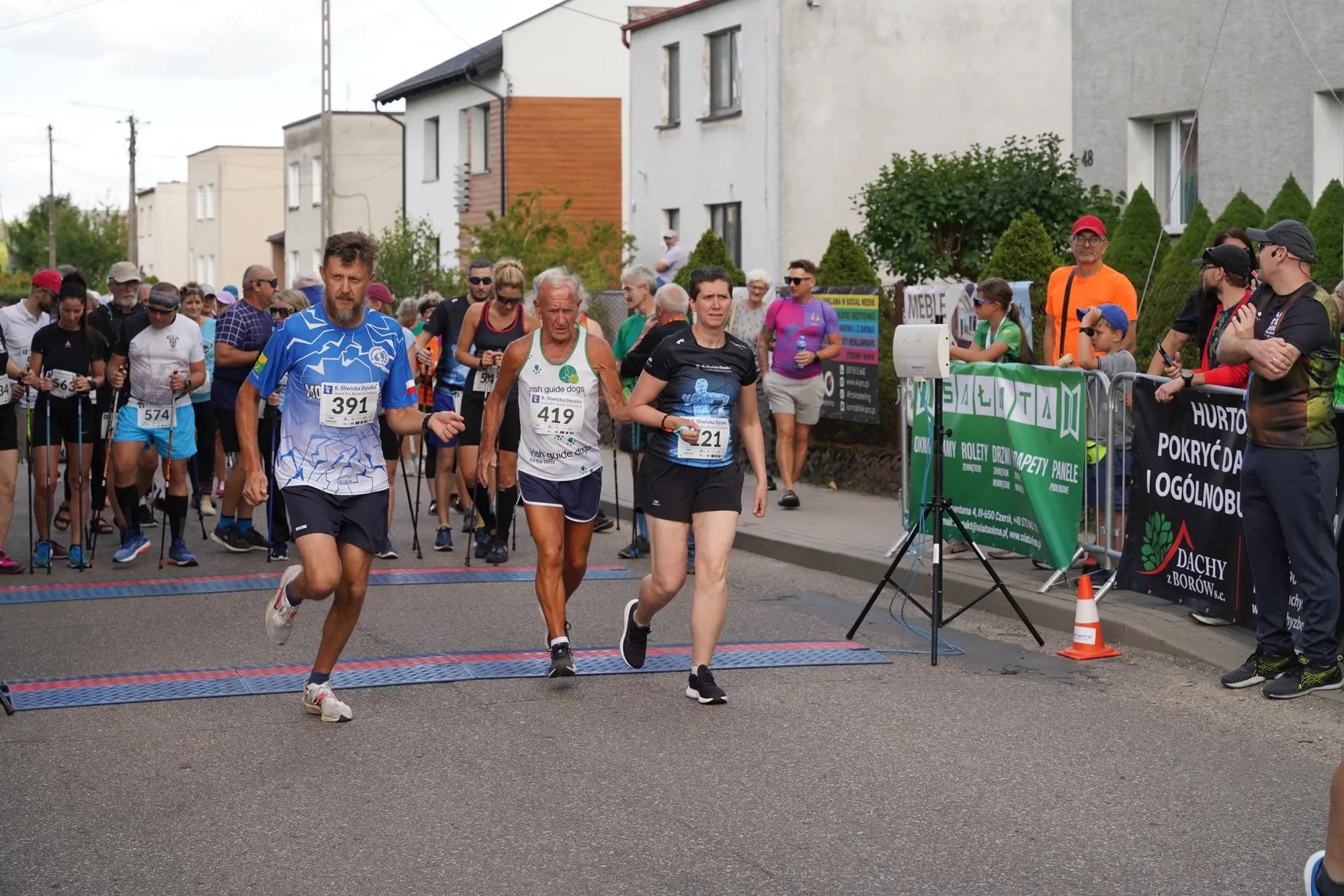 osoby przebiegają przez start