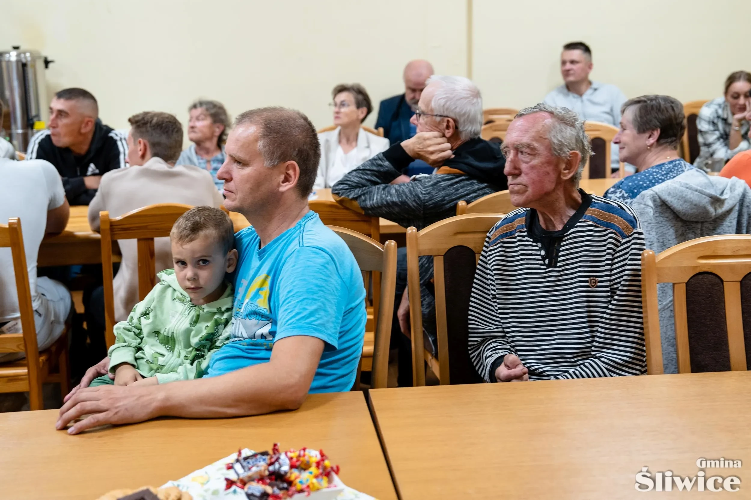 mieszkańcy siedzą przy stołach