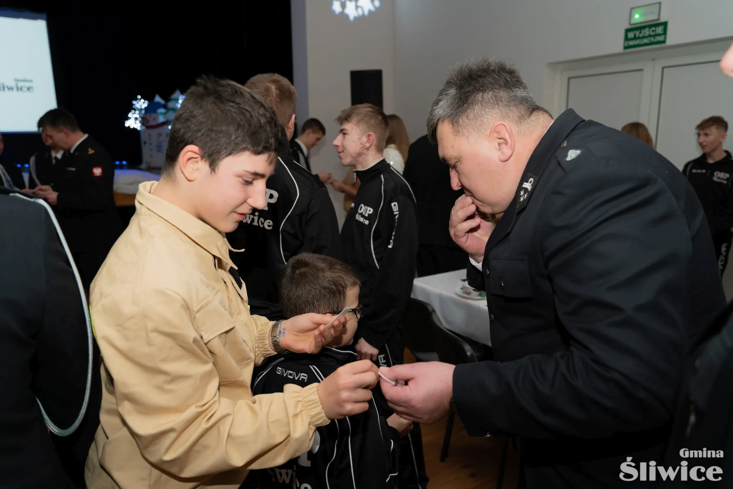 chłopiec z mdp dzieli się opłatkiem ze strażakiem