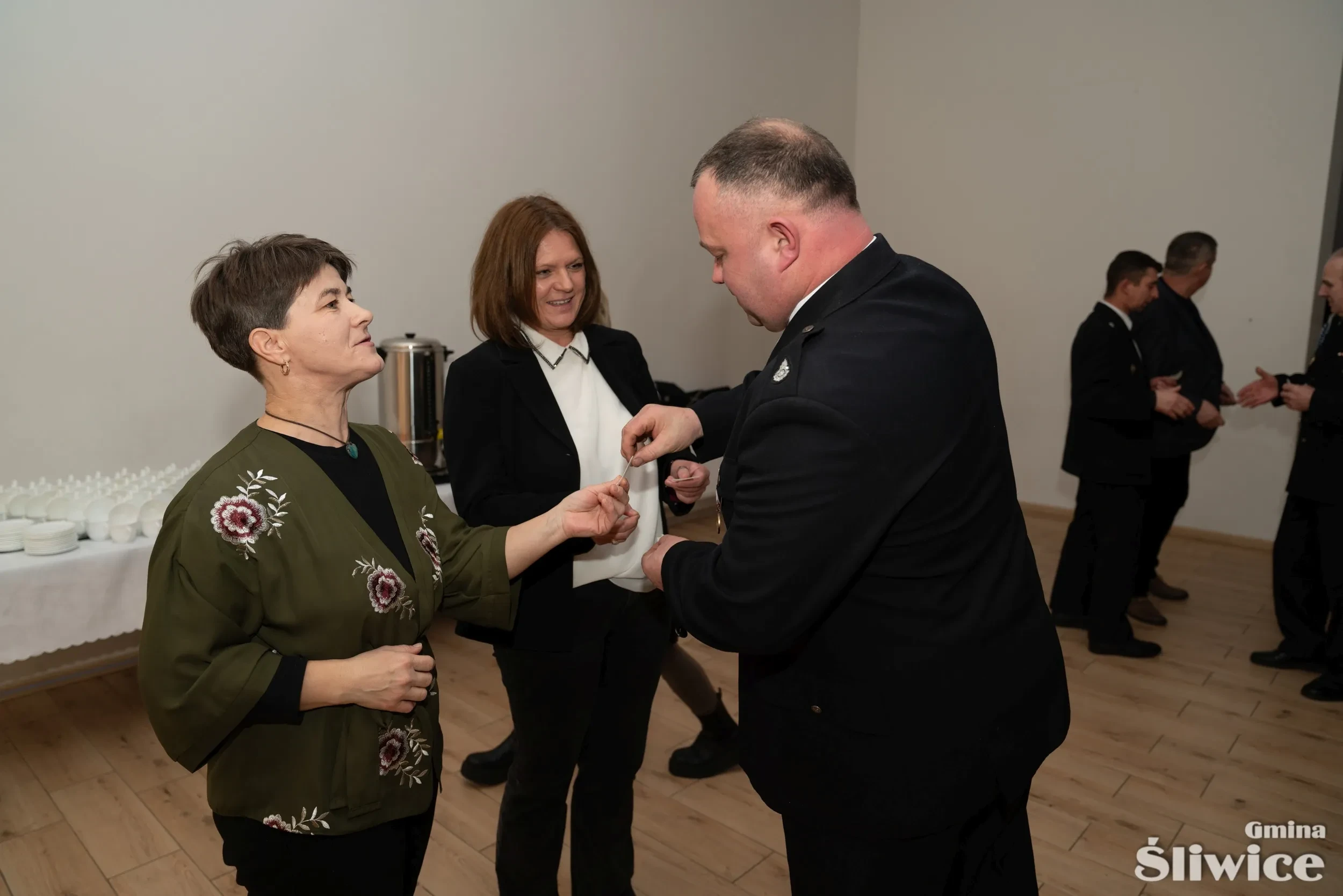 mężczyzna dzieli się opłatkiem z dwiema kobietami