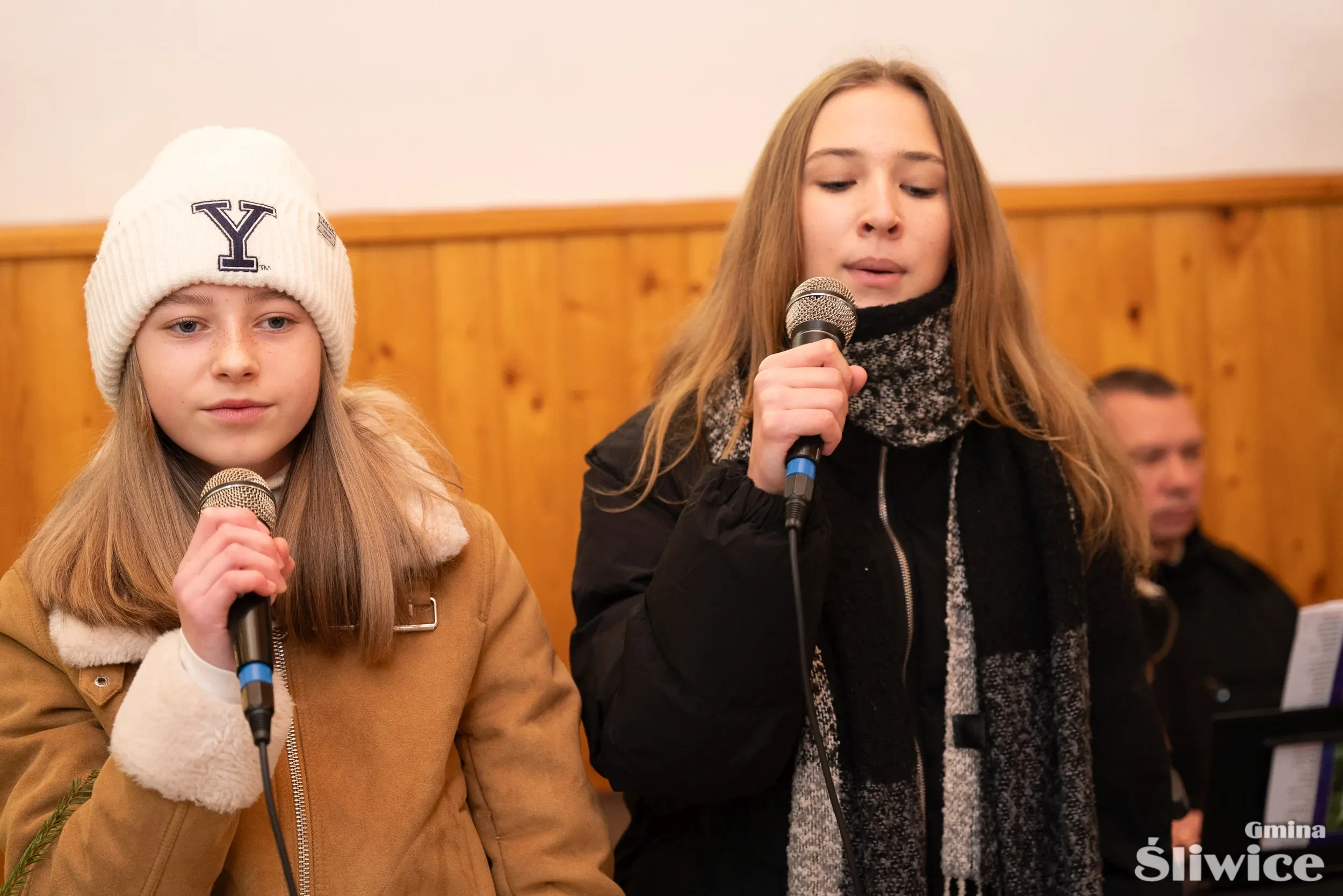 dwie dziewczyny trzymają mikrofon