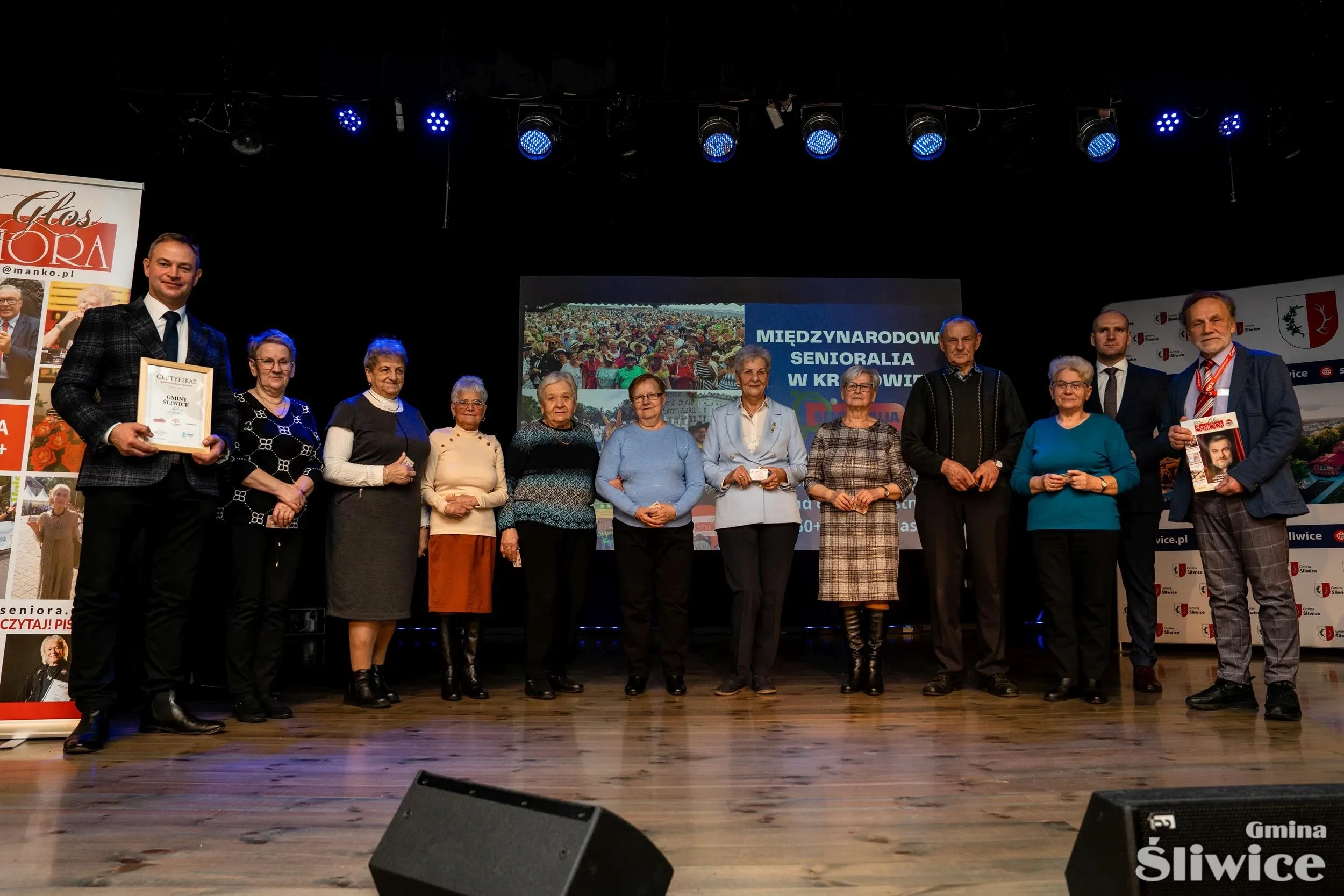 seniorzy z kartami na scenie