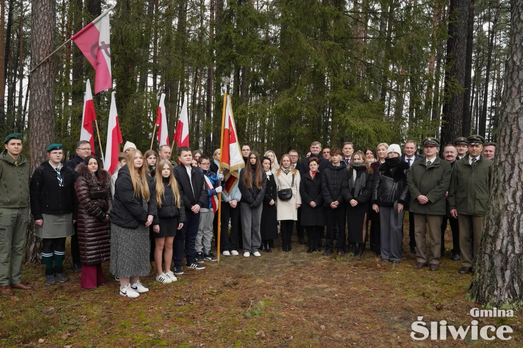 zgromadzone osoby podczas wręczania kwiatów