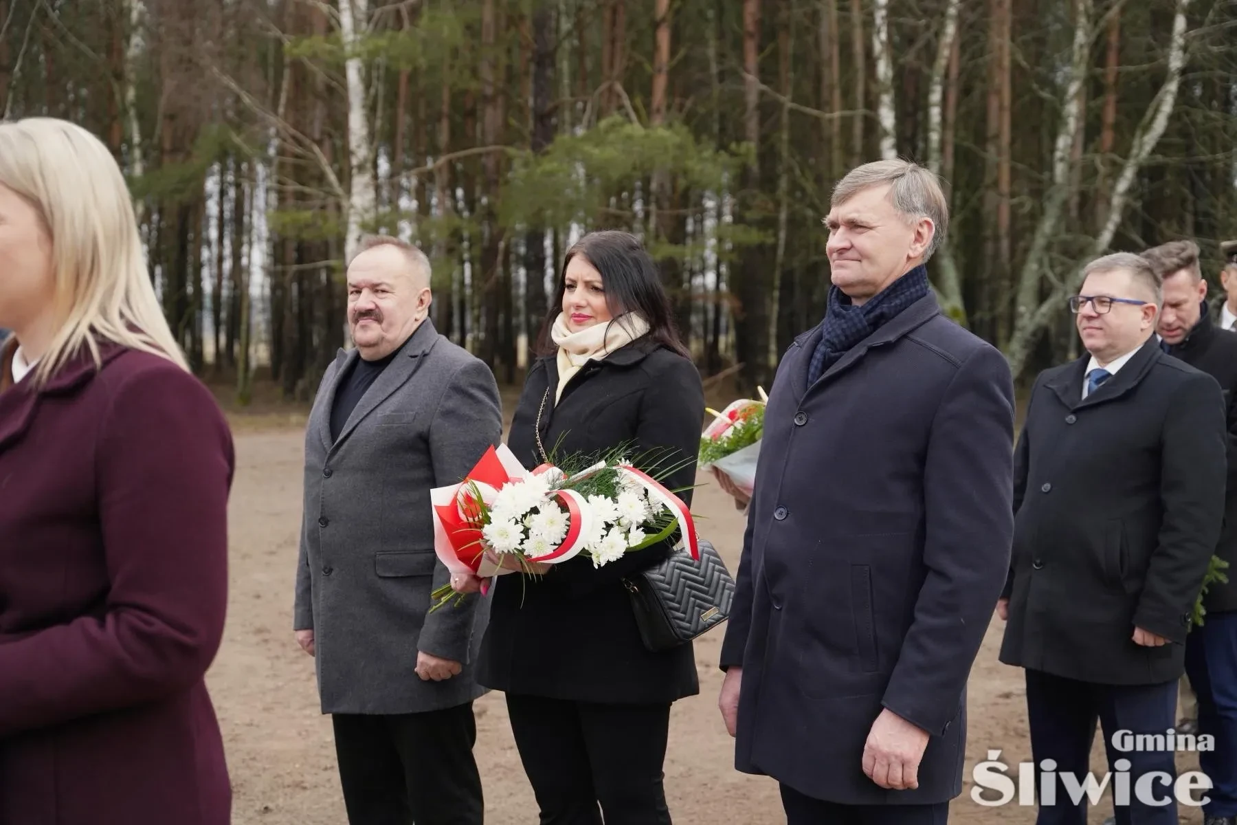 reprezentacja radnych stoi z kwiatami