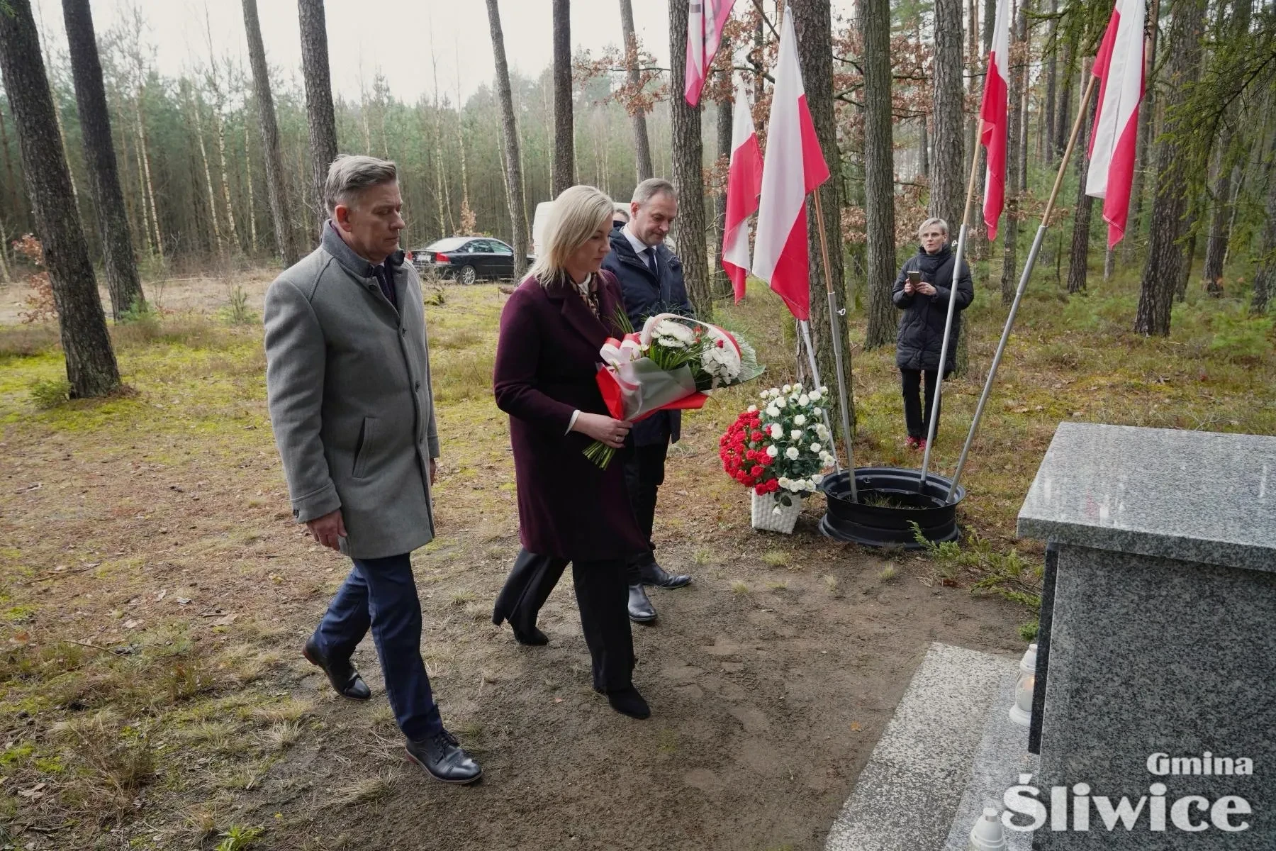 sekretarz, wicewójt wójta i wójt składa kwiaty
