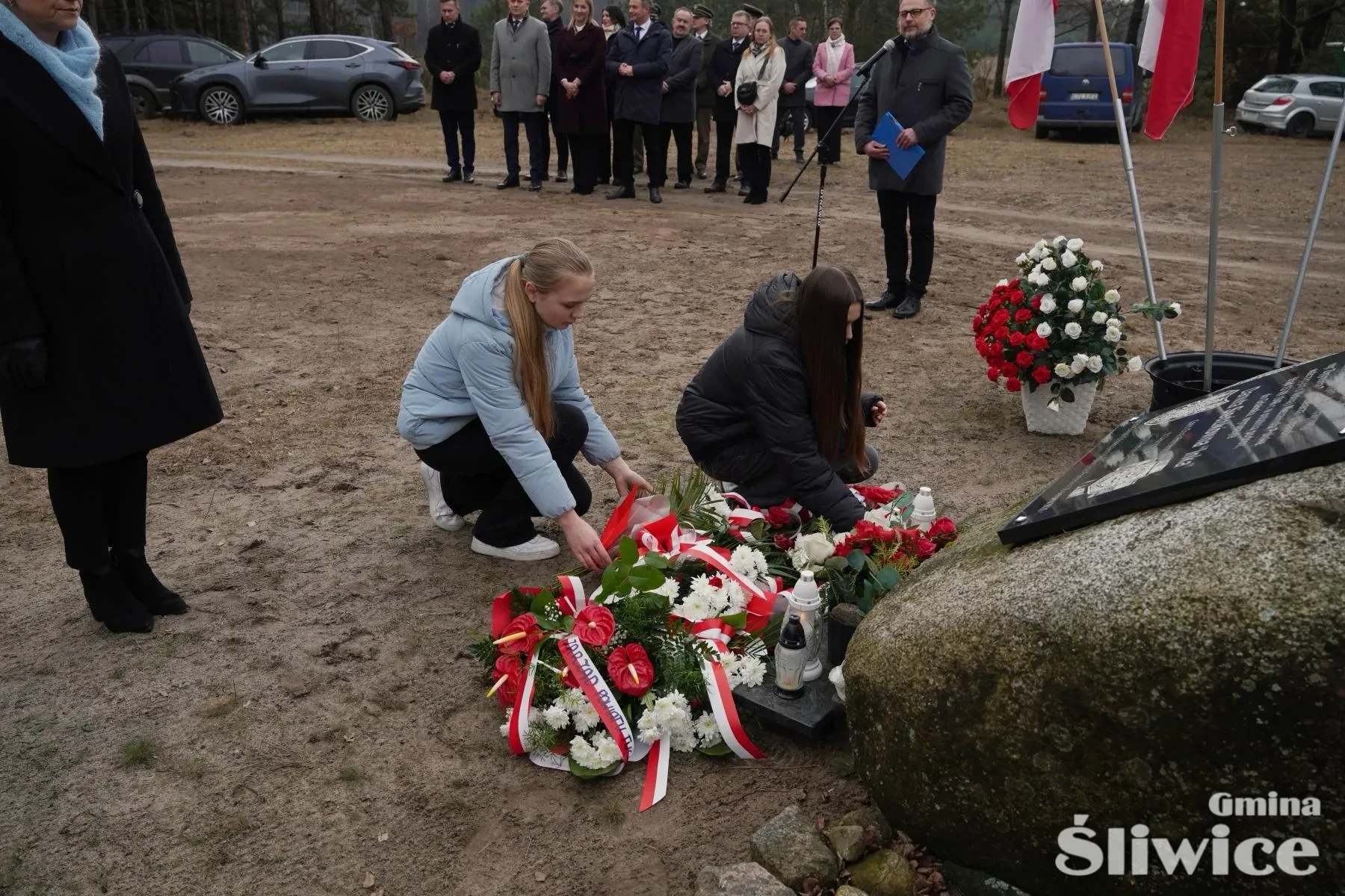 dwójka dzieci kładzie kwiaty