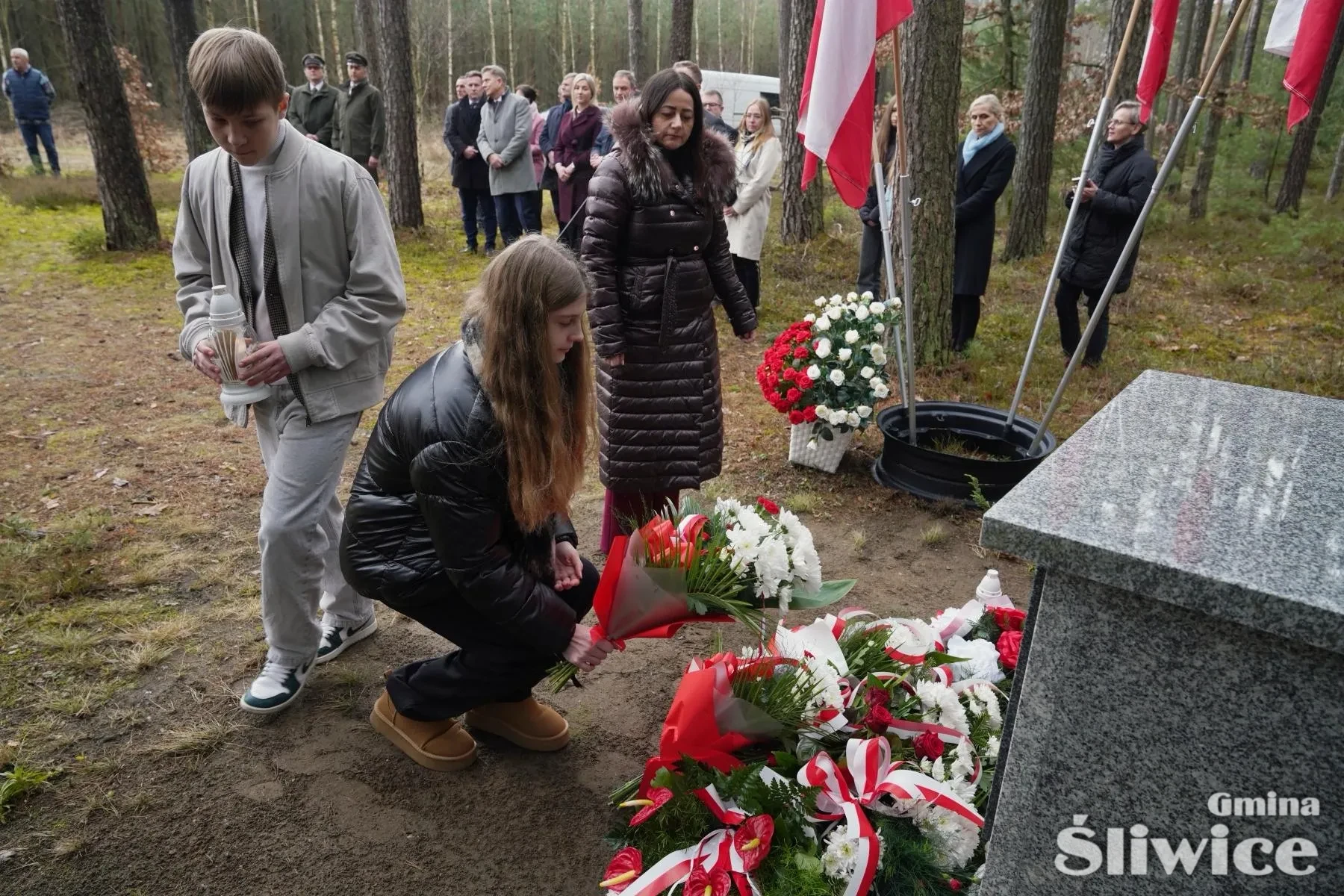 szkoła podstawowa ze śliwiczek składa kwiaty i znicz