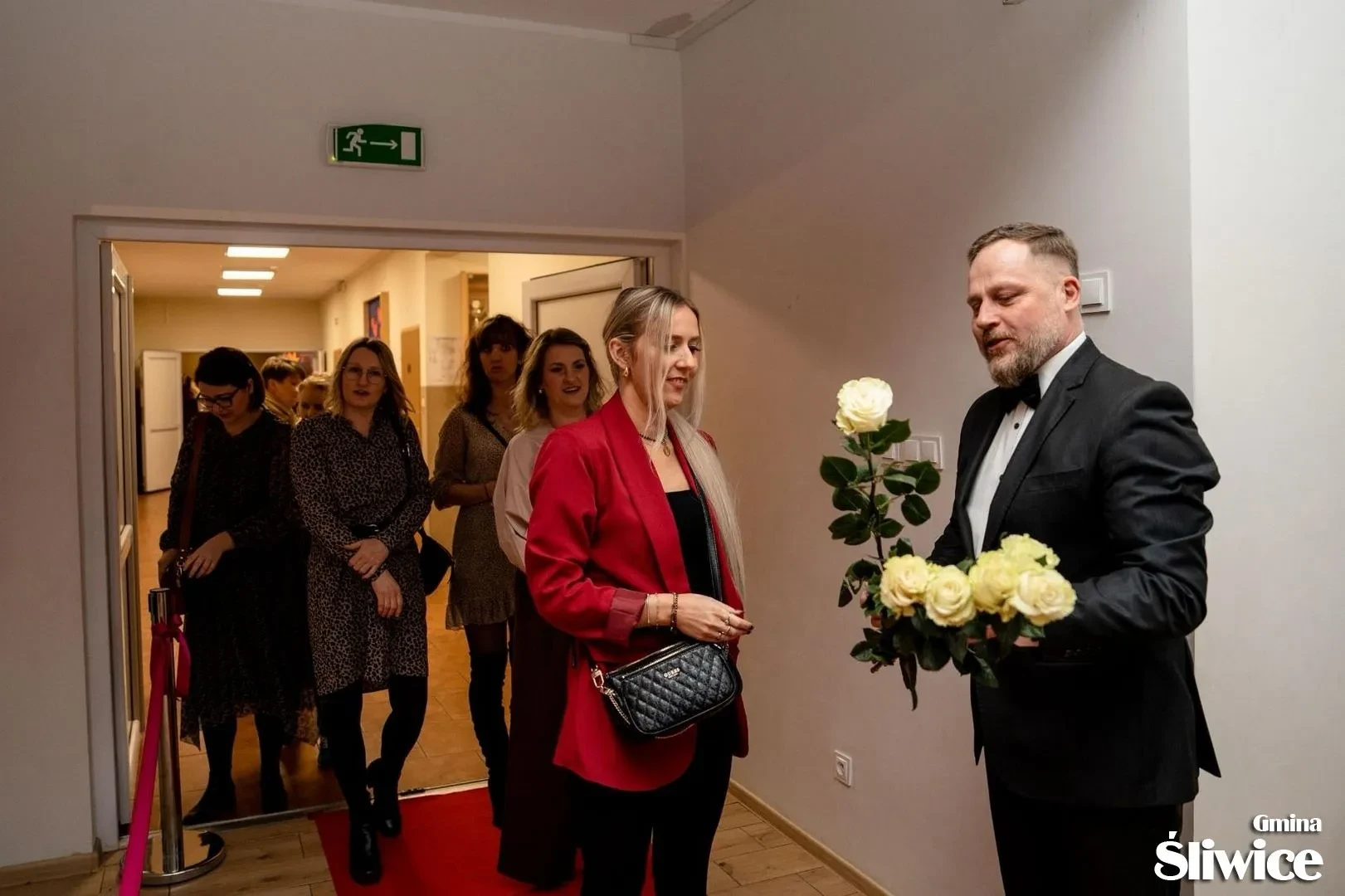 mężczyzna wręczający kwiaty kobietom