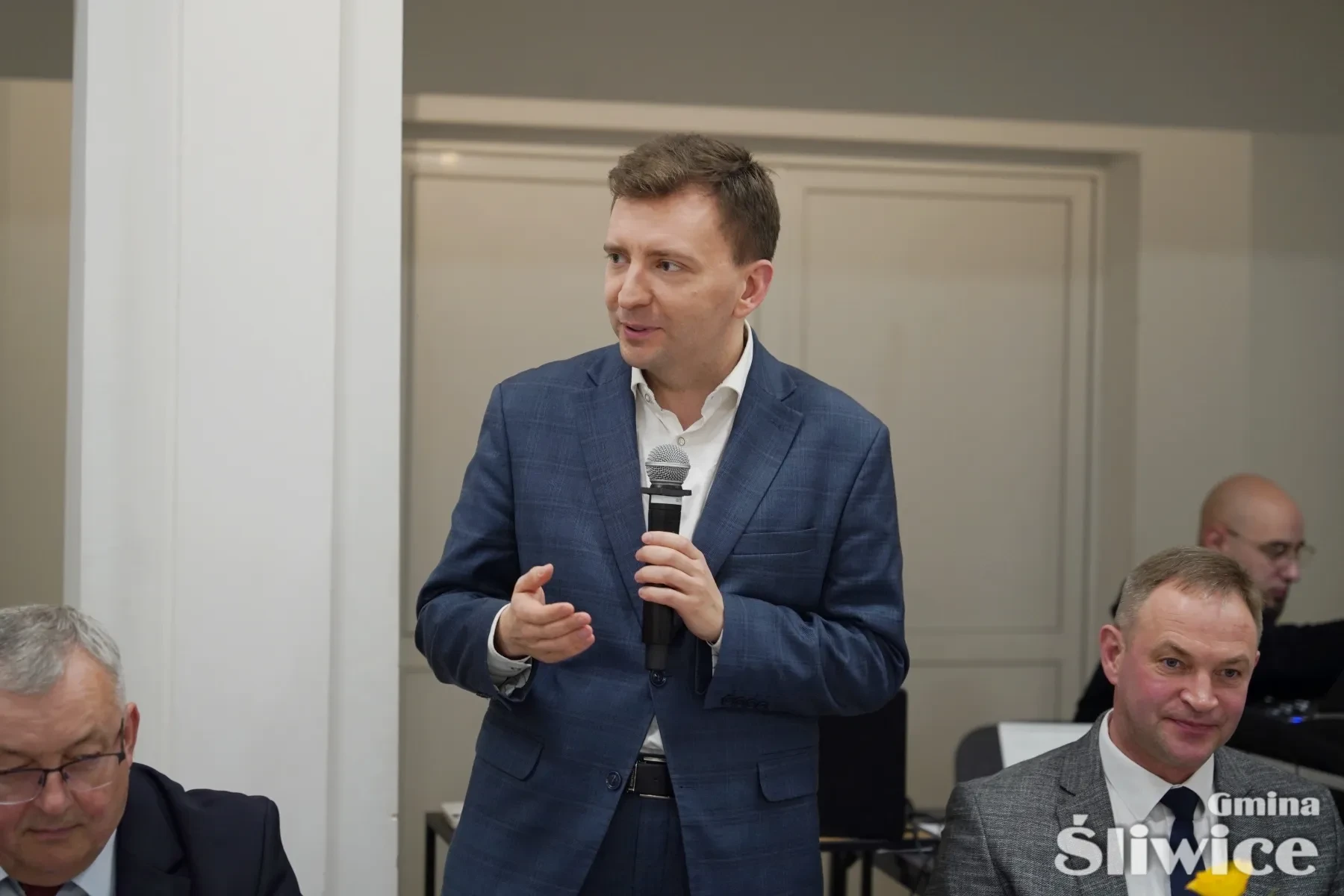 mężczyzna przemawiający do mikrofonu
