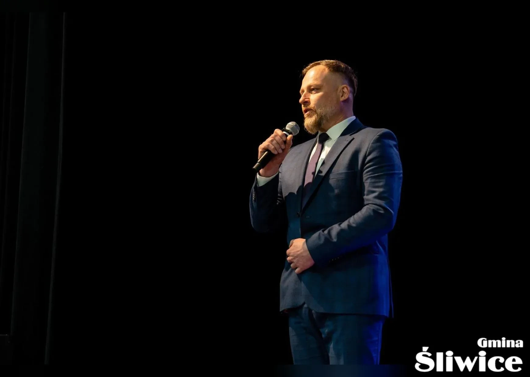 meżczyzna przemawia do mikrofonu