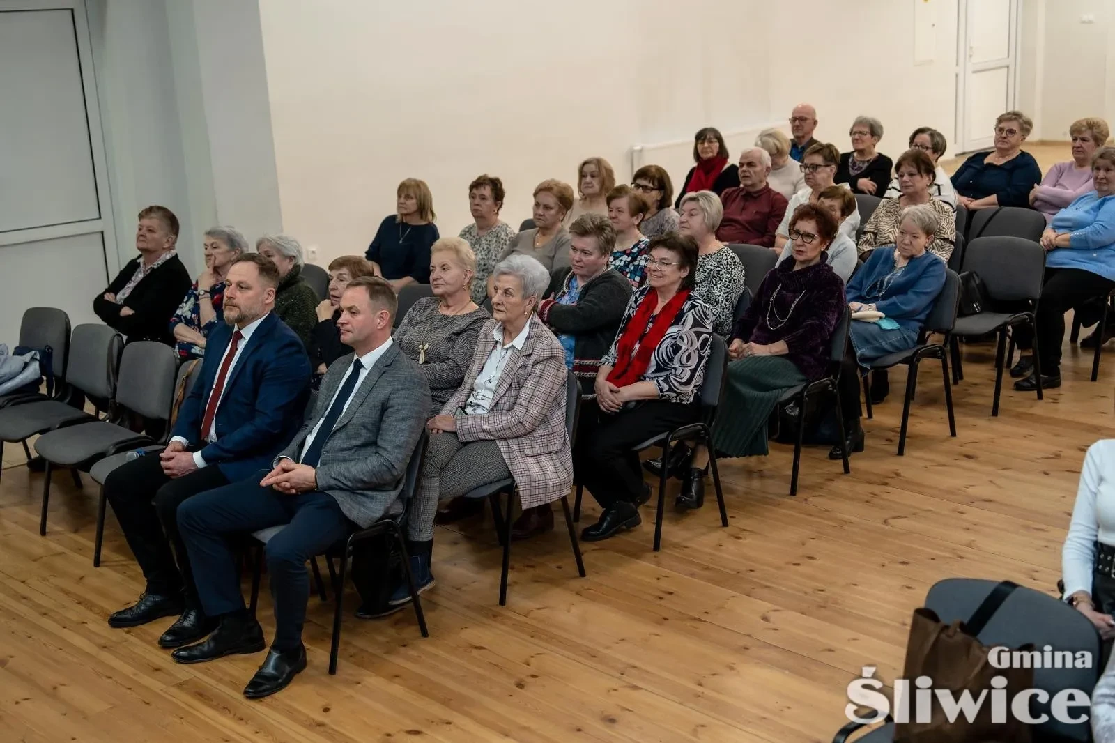 siedząca grupa osób zgromadzonych