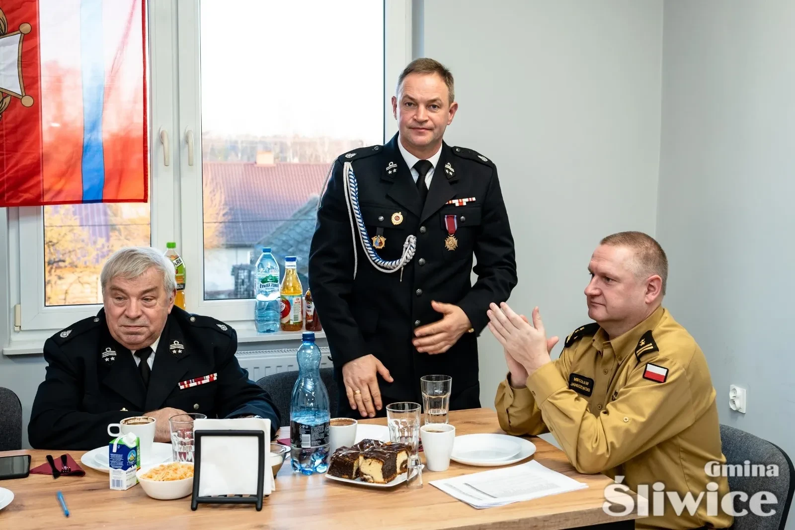 trzech siedzących mężczyzn przy stole