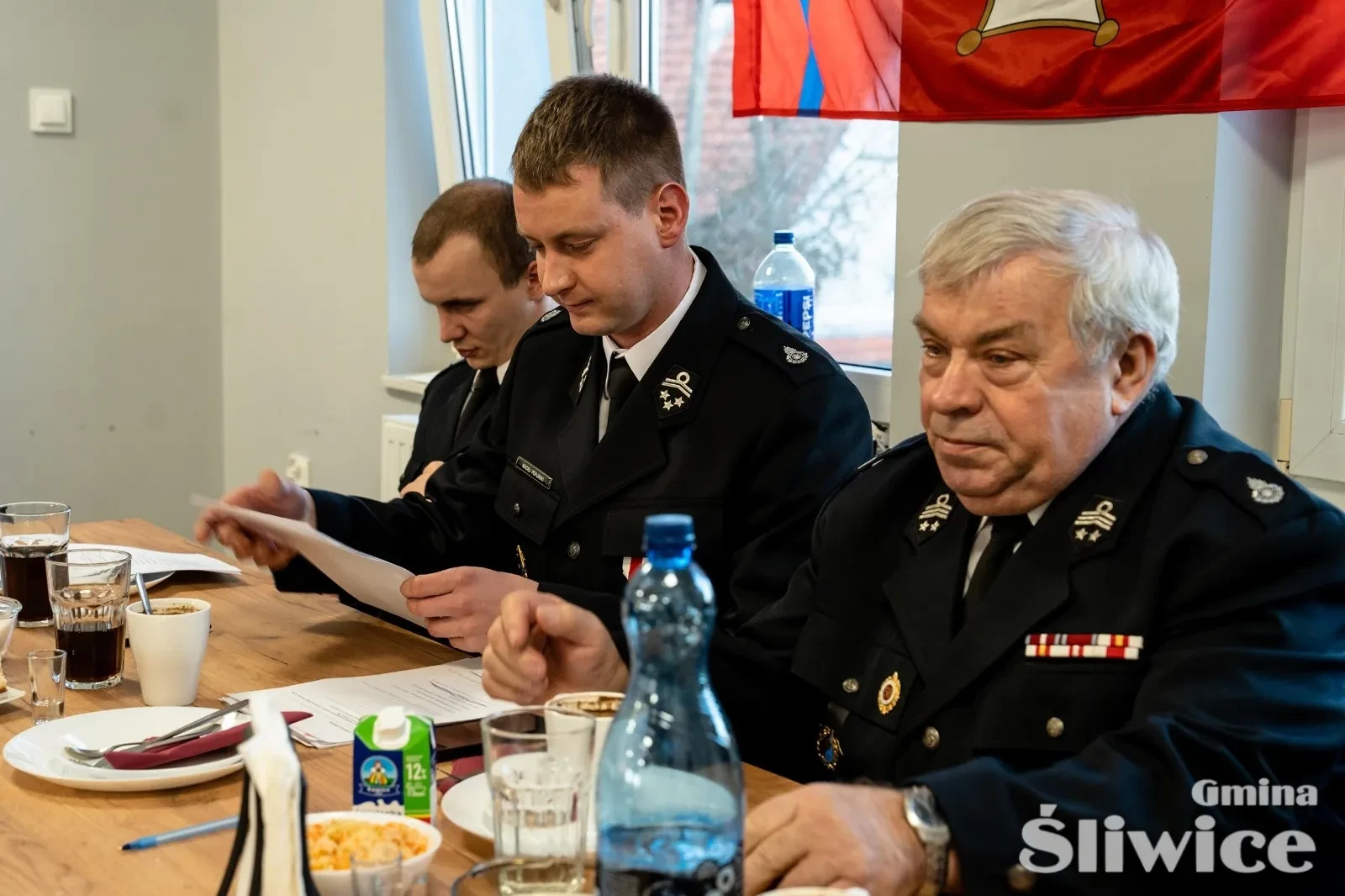 trzech mężczyzn siedzących przy stole