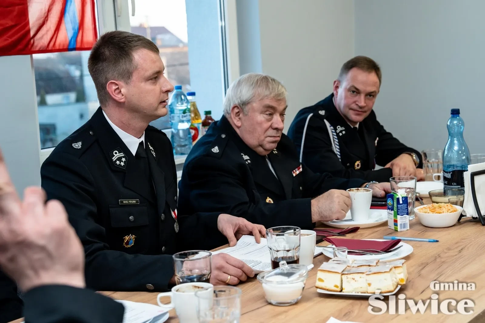 trzech siedzących mężczyzn przy stole