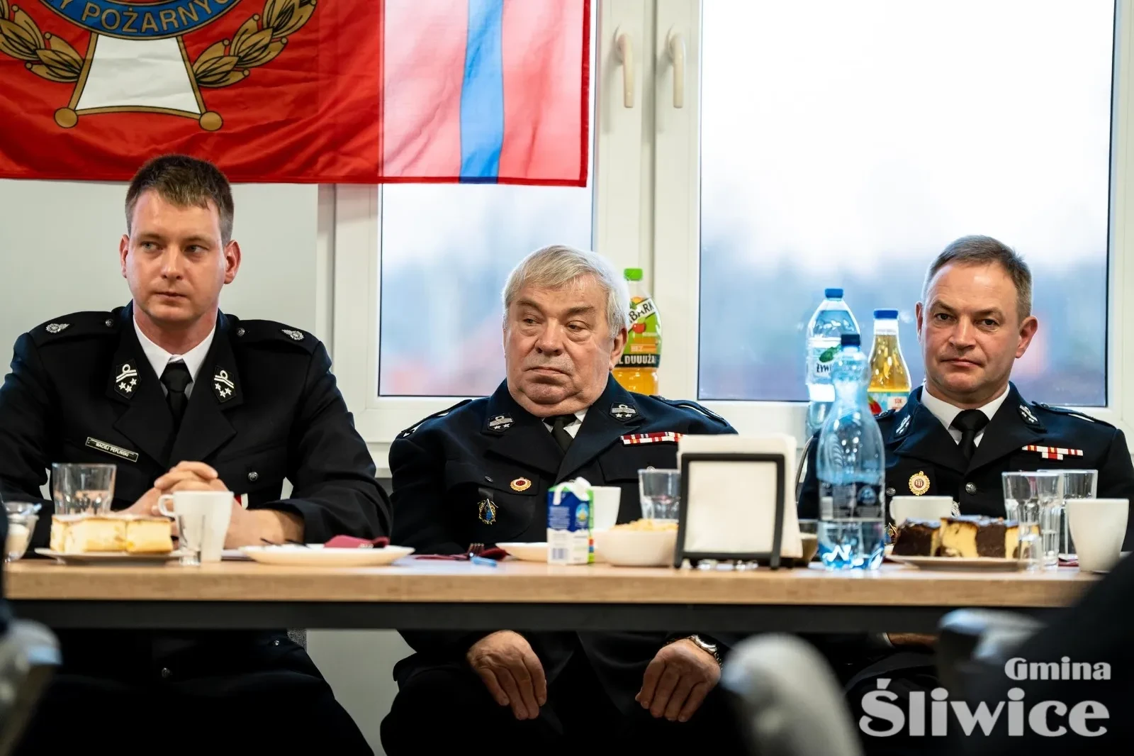 trzech siedzących mężczyzn przy stole