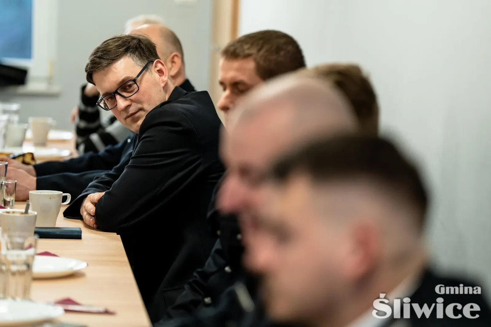 grupa siedzących mężczyzn przy stole