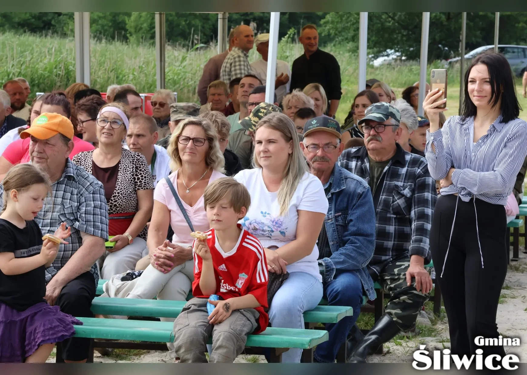 zebrani siedzą na ławkach