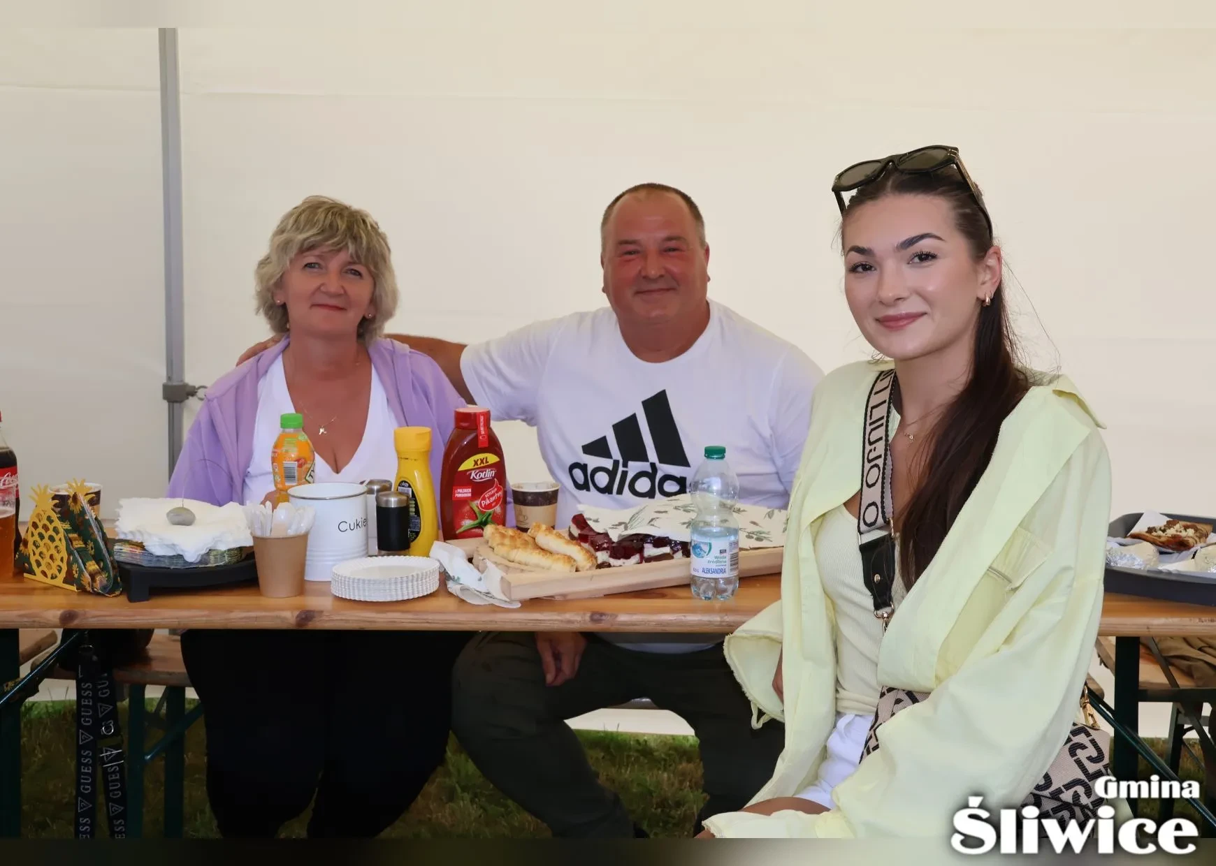 goście pod namiotem przy stole