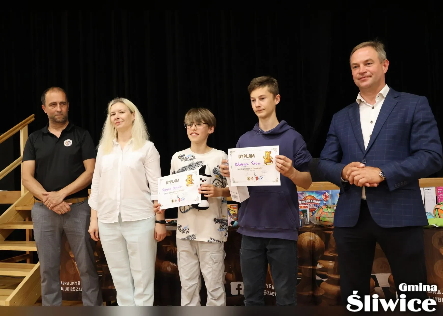 dwóch chłopców z dyplomami