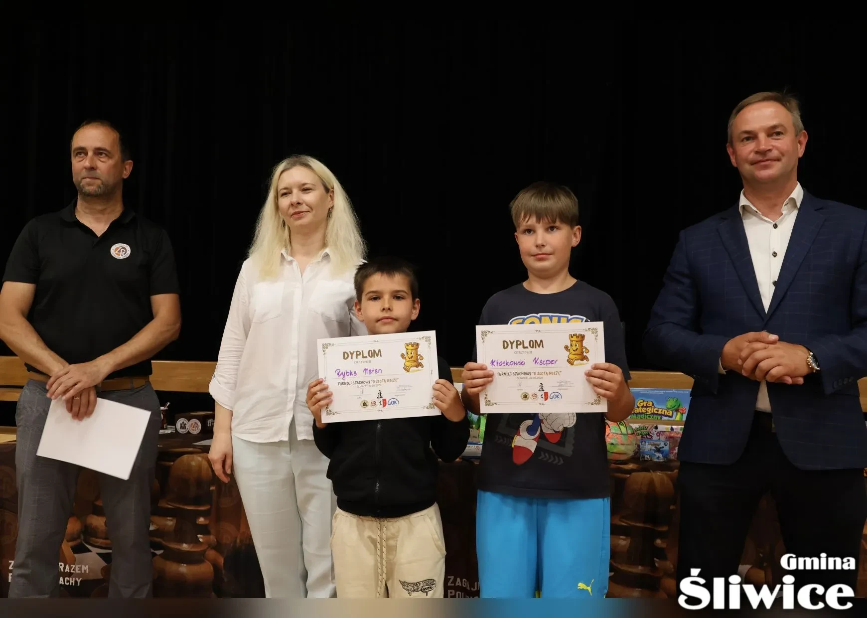 dwóch chłopców z dyplomami