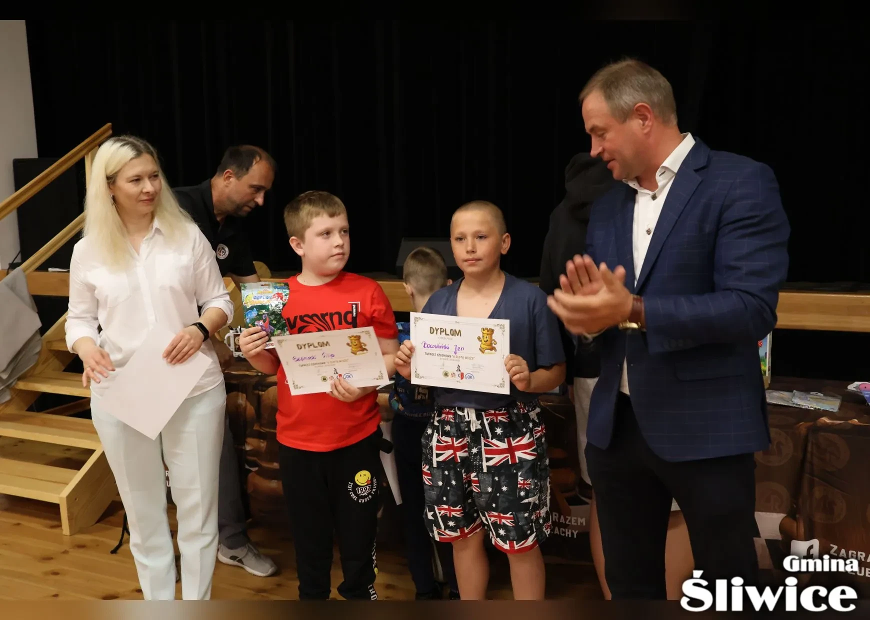 dwóch chłopców z dyplomami