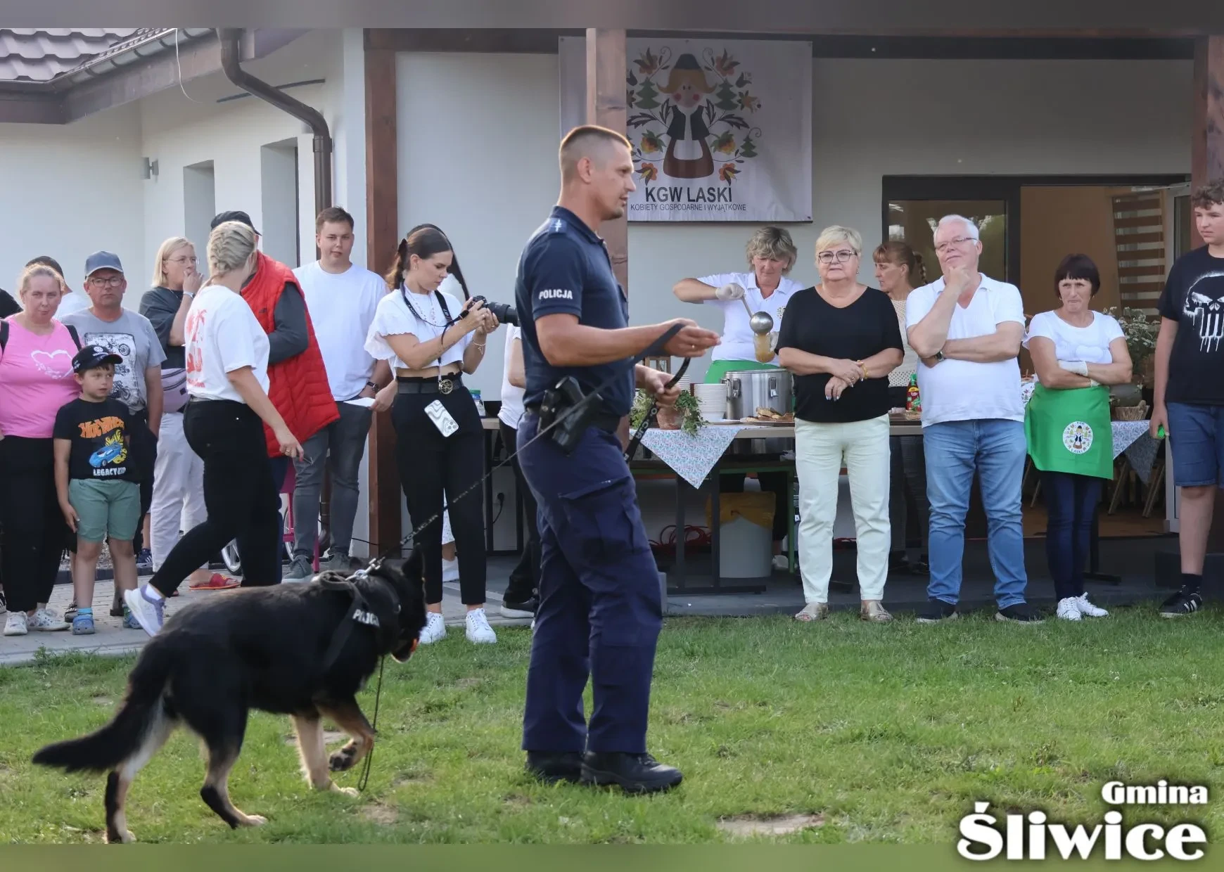 policjant z psem policyjnym chodzi po terenie