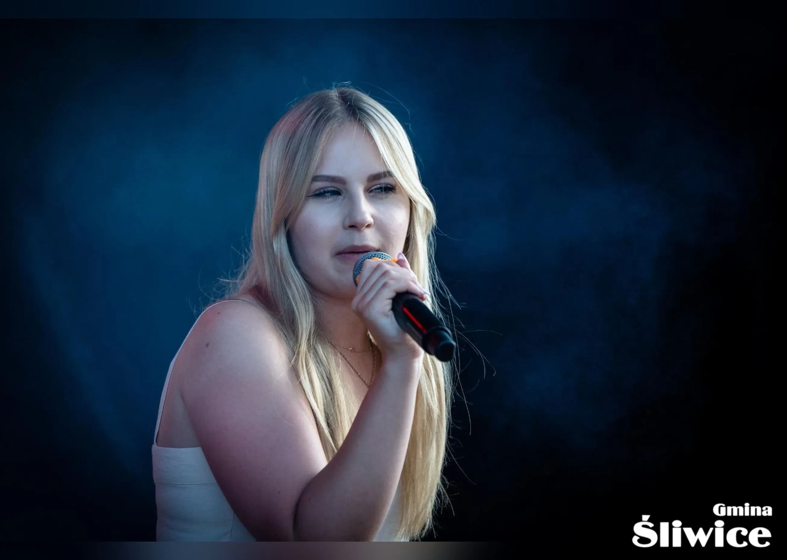 kobieta w blond włosach śpiewa