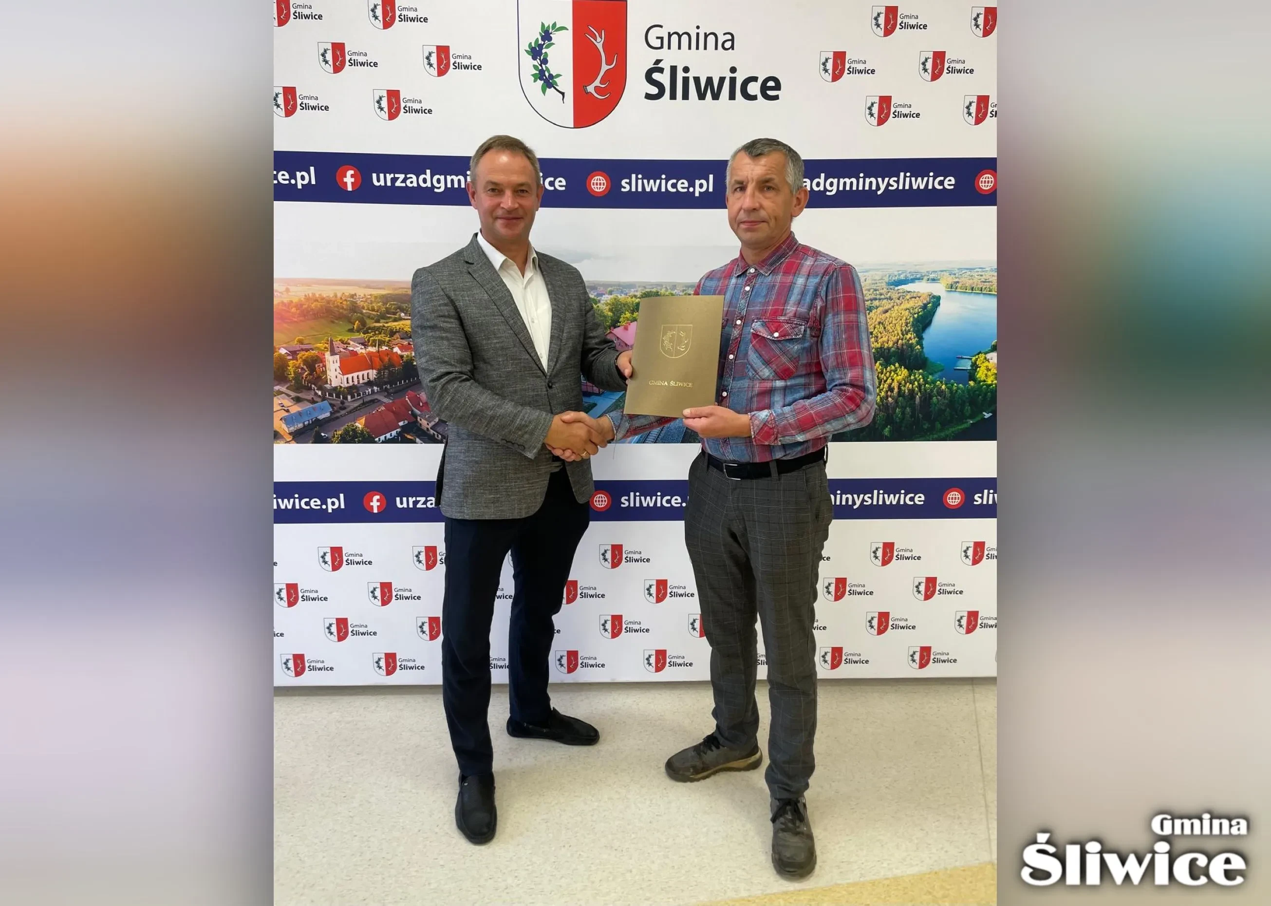 wójt i wykonawca trzymają umowę, w tle baner gminy śliwice