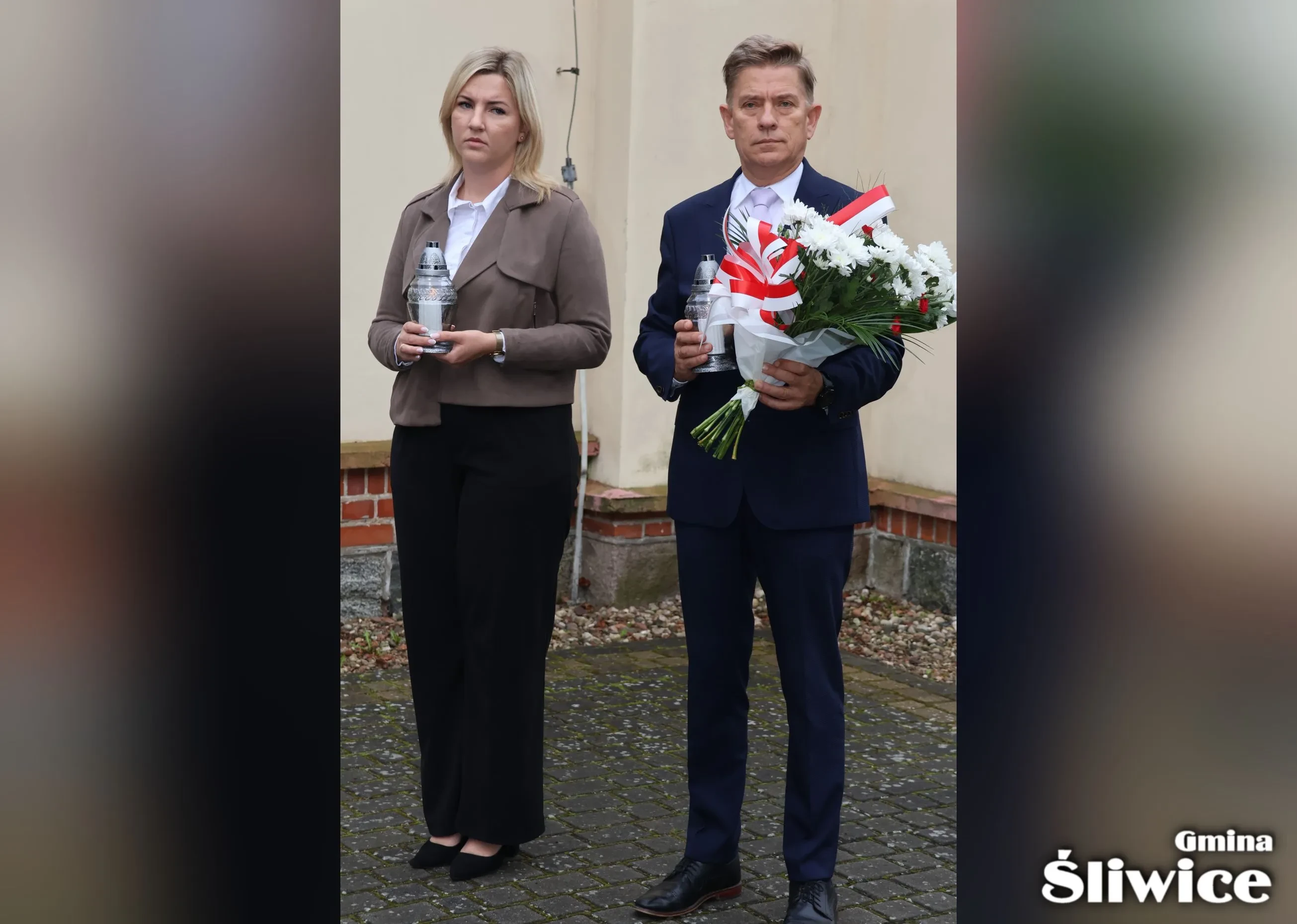 wicewójt trzyma znicz, sekretarz trzyma kwiaty