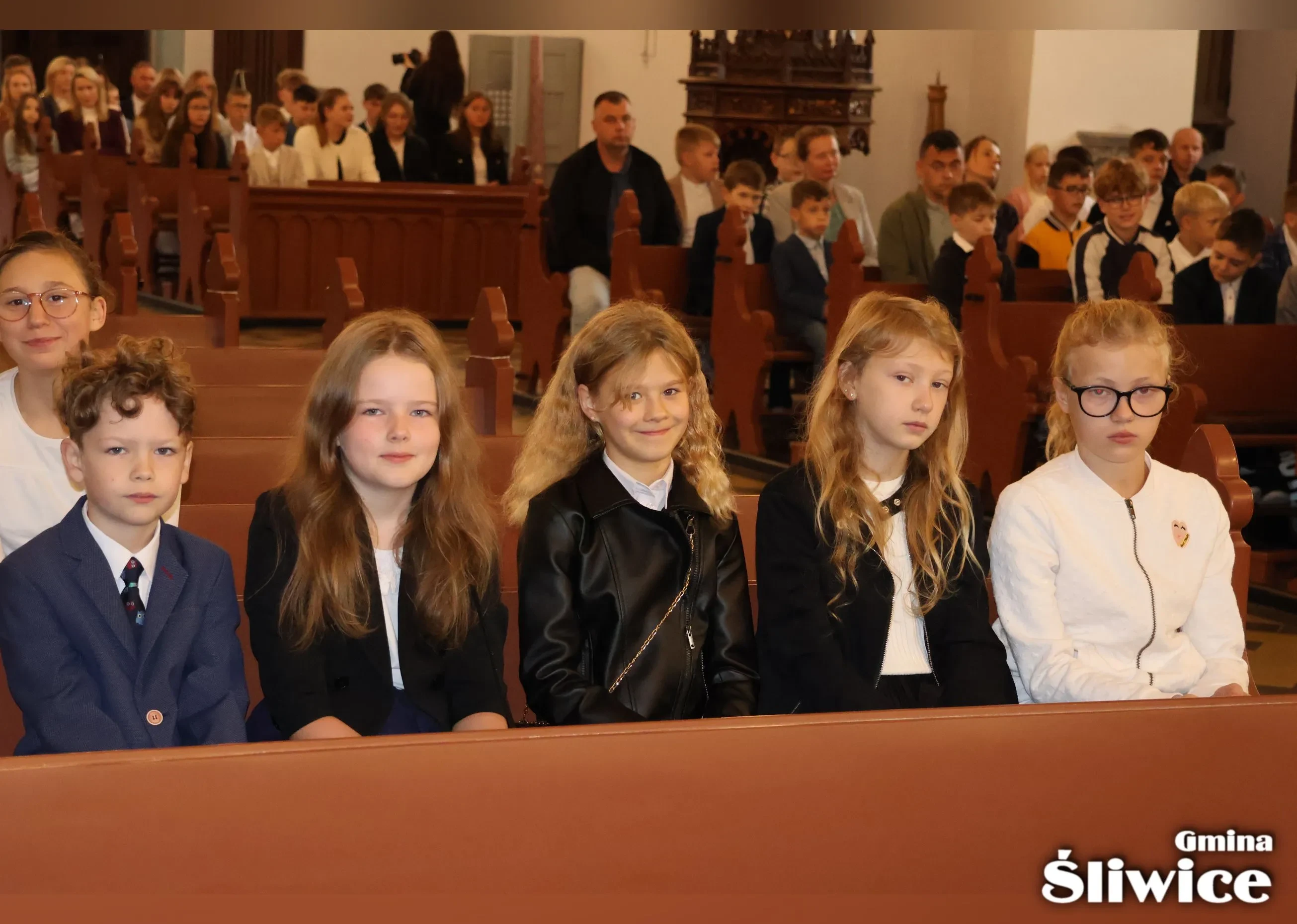 dzieci siedzą w kościele na mszy