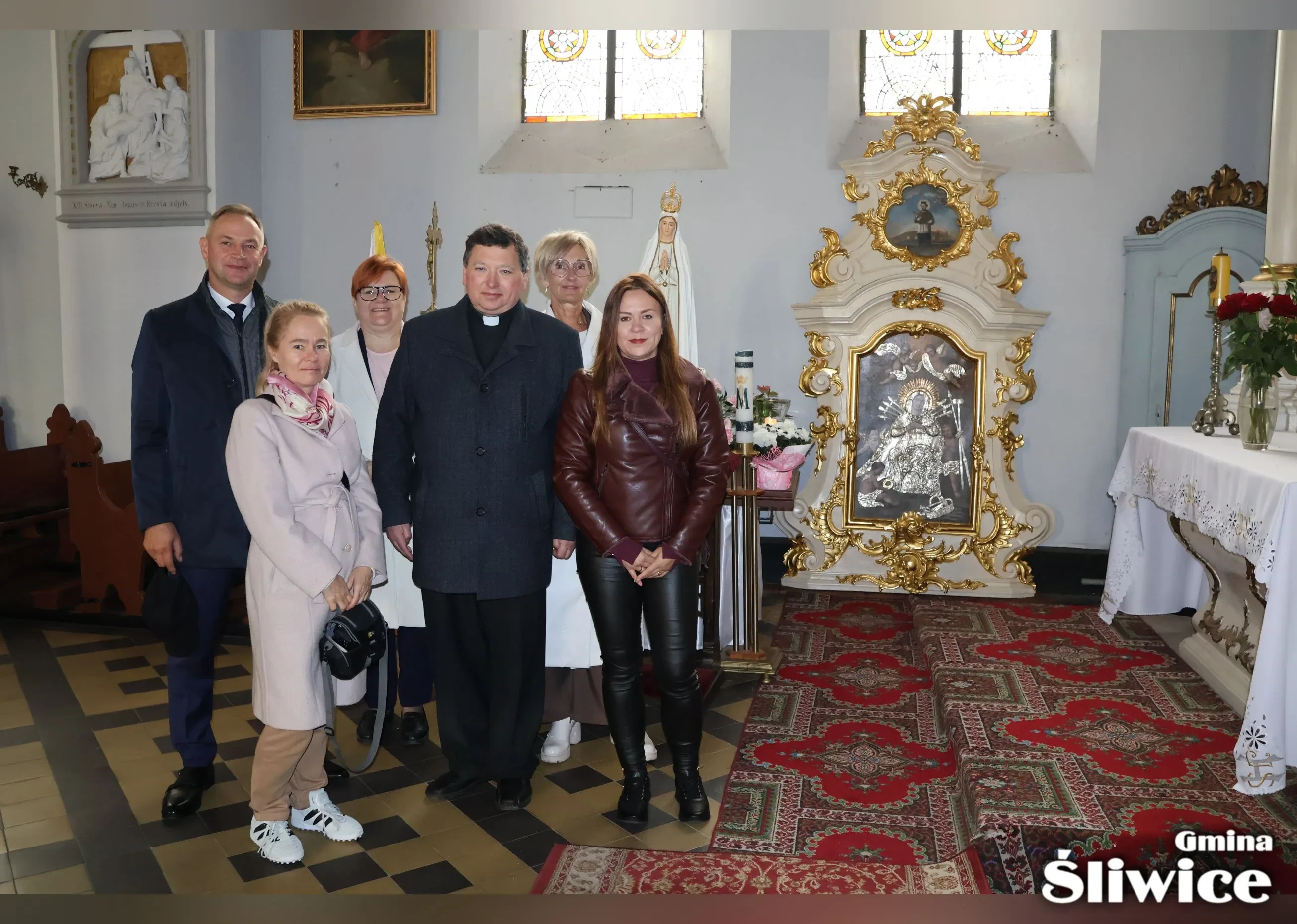zebrani przy odrestaurowanym ołtarzu